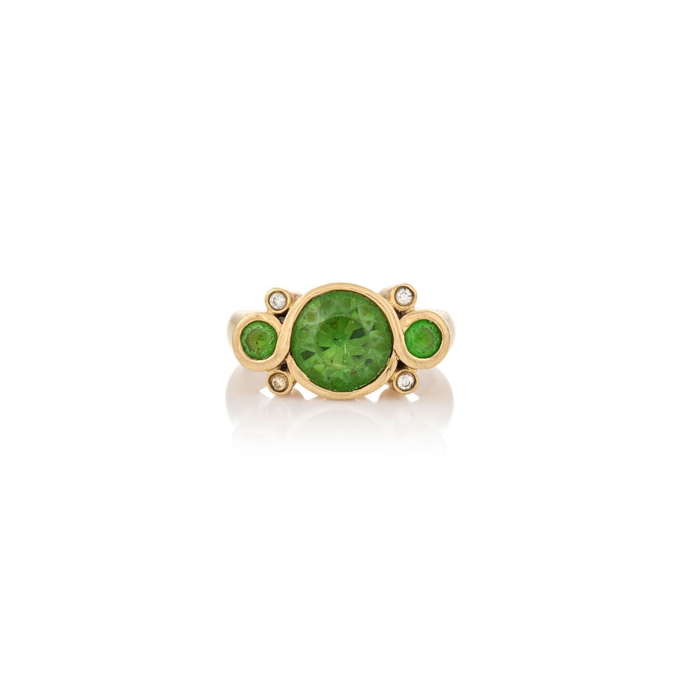A DEMANTOID GARNET RING: A DEMANTOID GARNET RING Centering a circular-cut demantoid garnet measuring approximately 8.21 x 8.23 x 5.36 mm, flanked by circular-cut demantoid garnets, with full-cut diamond accents, 14k gold