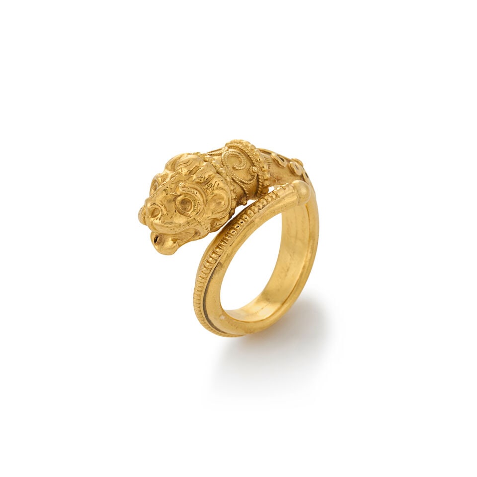 ZOLOTAS: A 22K GOLD LION RING: ZOLOTAS: A 22K GOLD LION RING The bypass ring with a lion's head to one end, applied bead and ropework accents, weight 5.0 dwt, maker's mark for Zolotas, in Ilias Lalaounis pouch, approximately size 5