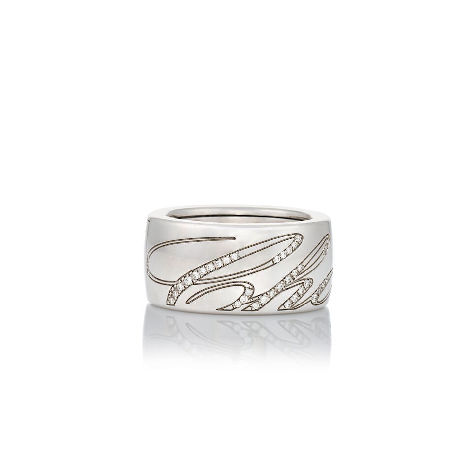 CHOPARD: AN 18K WHITE GOLD AND DIAMOND 'CHOPARDISSIMO' RING: CHOPARD: AN 18K WHITE GOLD AND DIAMOND 'CHOPARDISSIMO' RING Designed as a spinning ring with 'Chopard' written in full-cut diamonds, weight 12.6 dwt, signed Chopard, numbered, size approximately 6