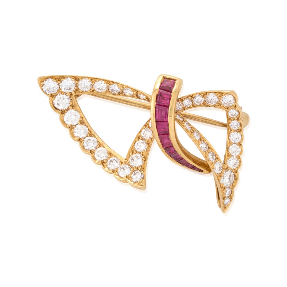 OSCAR HEYMAN: AN 18K GOLD, RUBY, AND DIAMOND PENDANT/BROOCH: OSCAR HEYMAN: AN 18K GOLD, RUBY, AND DIAMOND PENDANT/BROOCH Designed as a stylized bow set with full-cut diamonds, approximate total weight 1.30 carats, and calibré-cut rubies, weight 4.4 dwt, ma