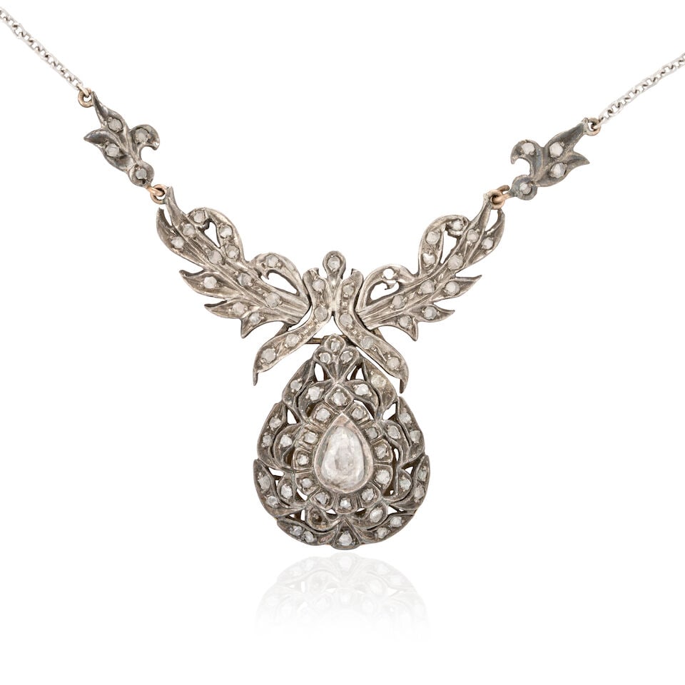 A DIAMOND PENDANT NECKLACE: A DIAMOND PENDANT NECKLACE Centering a foil-back pear-shaped rose-cut diamond, framed by rose-cut diamonds, in silver and low karat gold, joined to a 14k white gold chain, gross weight 9.5 dwt,