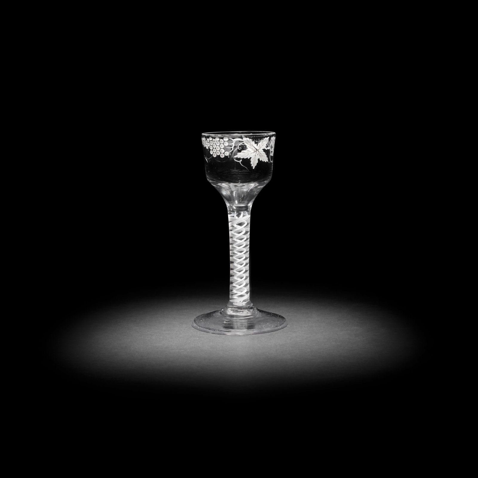 A Beilby enamelled opaque twist wine glass, circa 1765: A Beilby enamelled opaque twist wine glass, circa 1765 The ogee bowl painted in opaque white with a continuous band of fruiting vine, on a double-series stem with a pair of six-ply spiral bands outsid