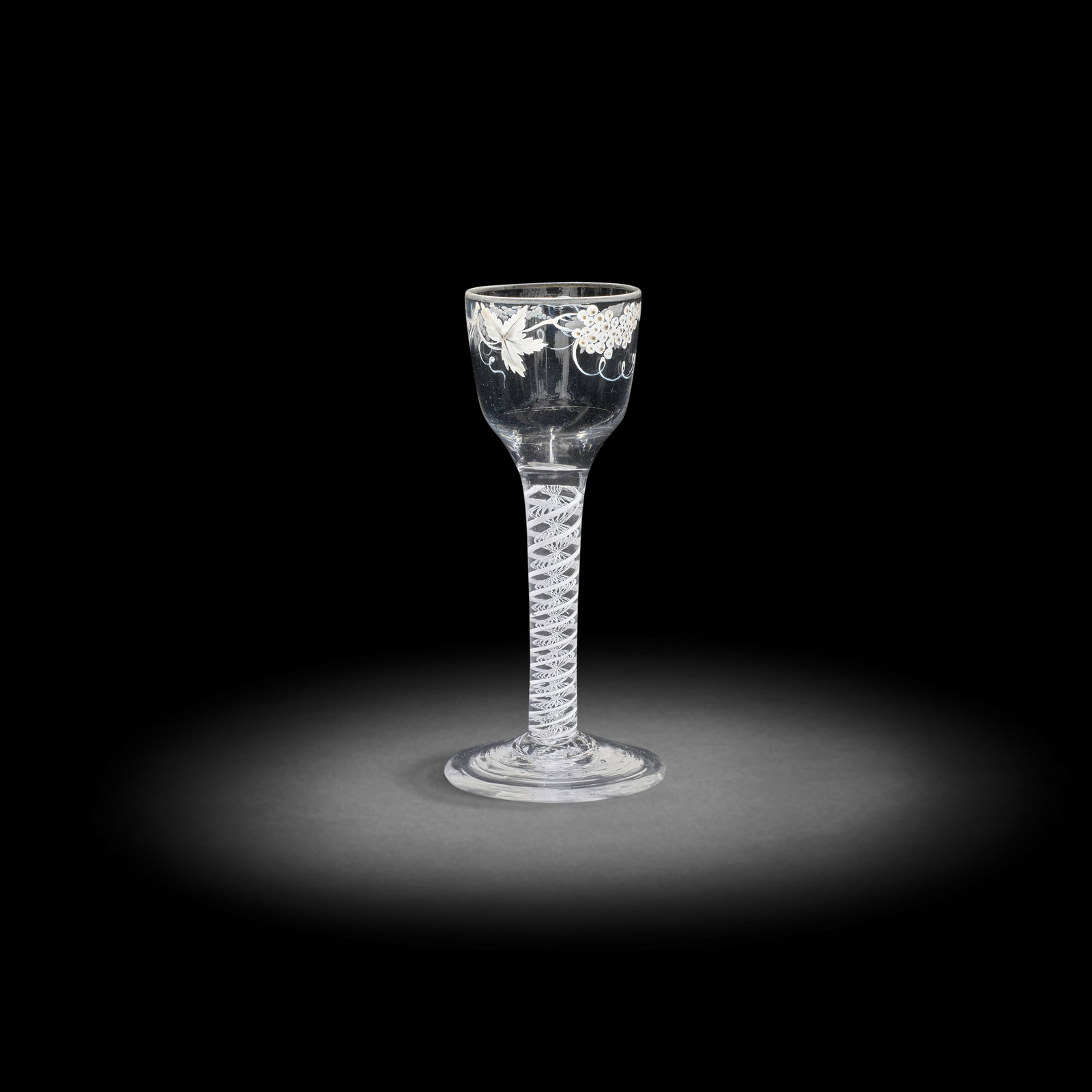 A Beilby enamelled opaque twist wine glass, circa 1765: A Beilby enamelled opaque twist wine glass, circa 1765 The ogee bowl painted with fruiting vine in opaque white, faint traces of gilding to the rim, set on a double-series stem containing a pair of he