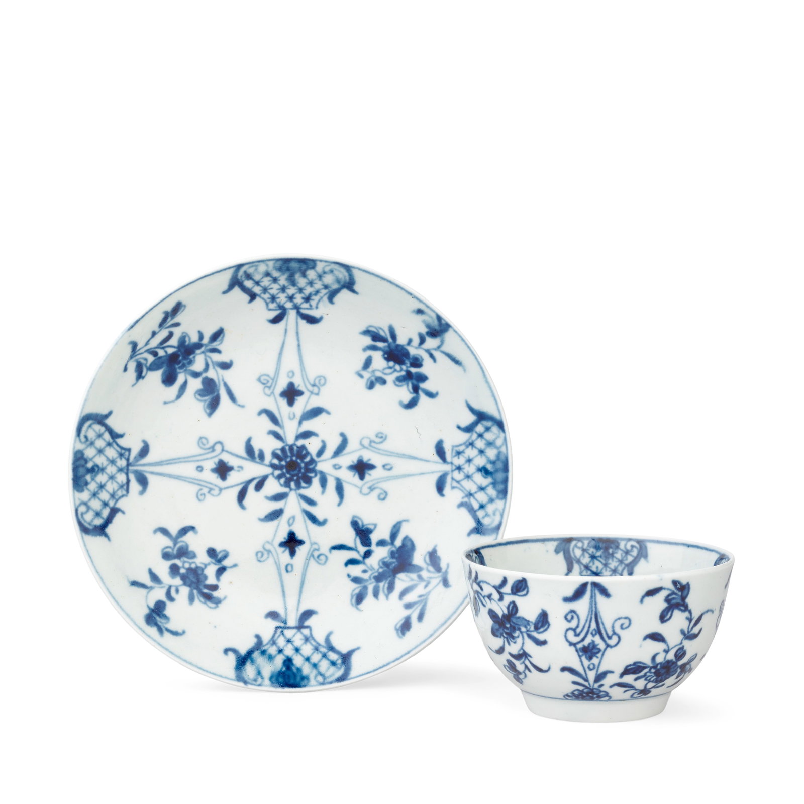 A good Worcester teabowl and saucer, circa 1757-58: A good Worcester teabowl and saucer, circa 1757-58 Painted in blue with small flower sprigs within a cruciform arrangement of shaped diaper panels at the rim linked by lozenge scroll-edged columns to