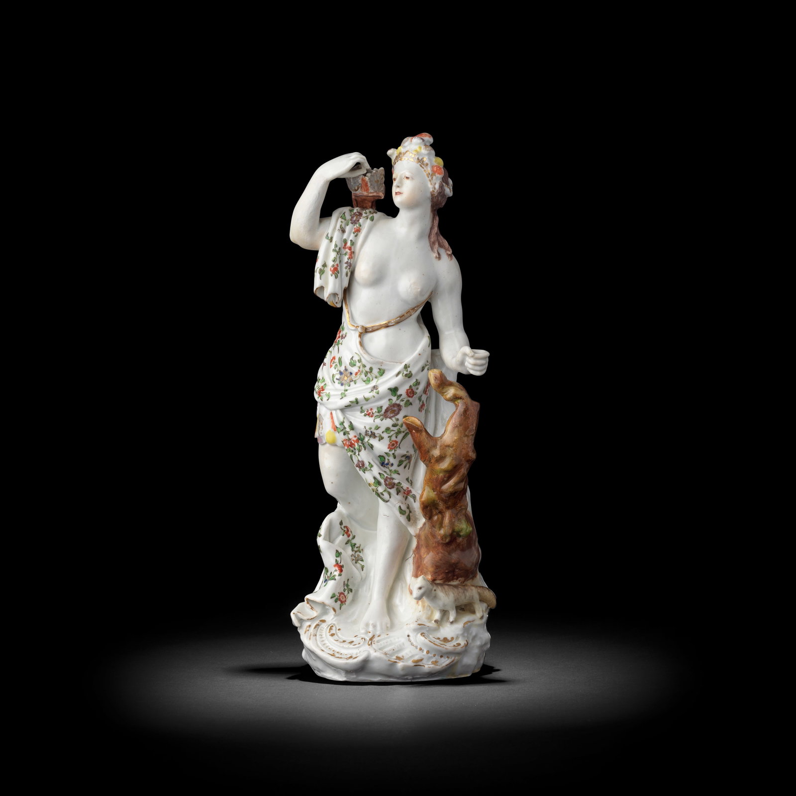 A Plymouth (William Cookworthy) figure of America, circa 1768-70: A Plymouth (William Cookworthy) figure of America, circa 1768-70 From a set of the Four Continents, modelled as a woman wearing a feathered headdress and finely painted and gilt drapery over a feather