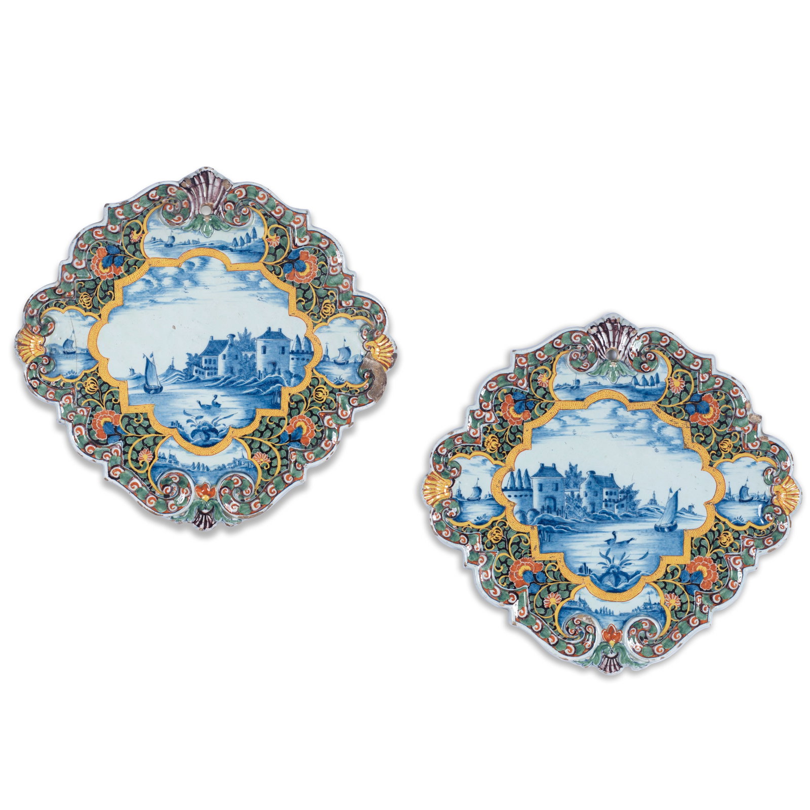 A pair of Dutch Delft plaques, second half 18th century: A pair of Dutch Delft plaques, second half 18th century Of lobed form moulded with a scrollwork rim with shells, painted in the centre in blue with river scenes, each the mirror image of the other, wi