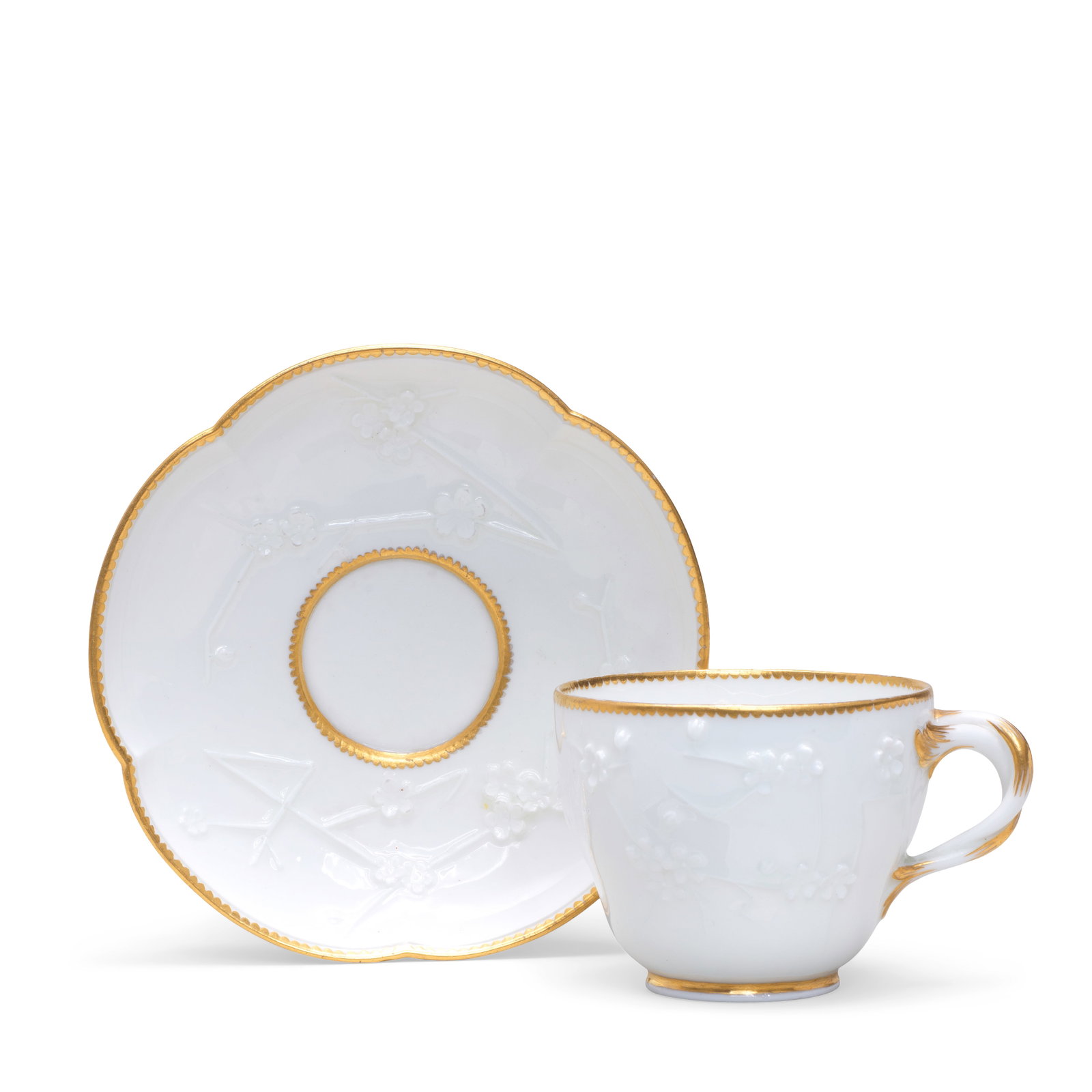 A Vincennes cup and saucer (gobelet Hébert à relief et soucoupe) , circa 1754-55: A Vincennes cup and saucer (gobelet Hébert à relief et soucoupe) , circa 1754-55 Of the second size, each moulded with flowering prunus branches, the handle embellished in gilding, gilt dent