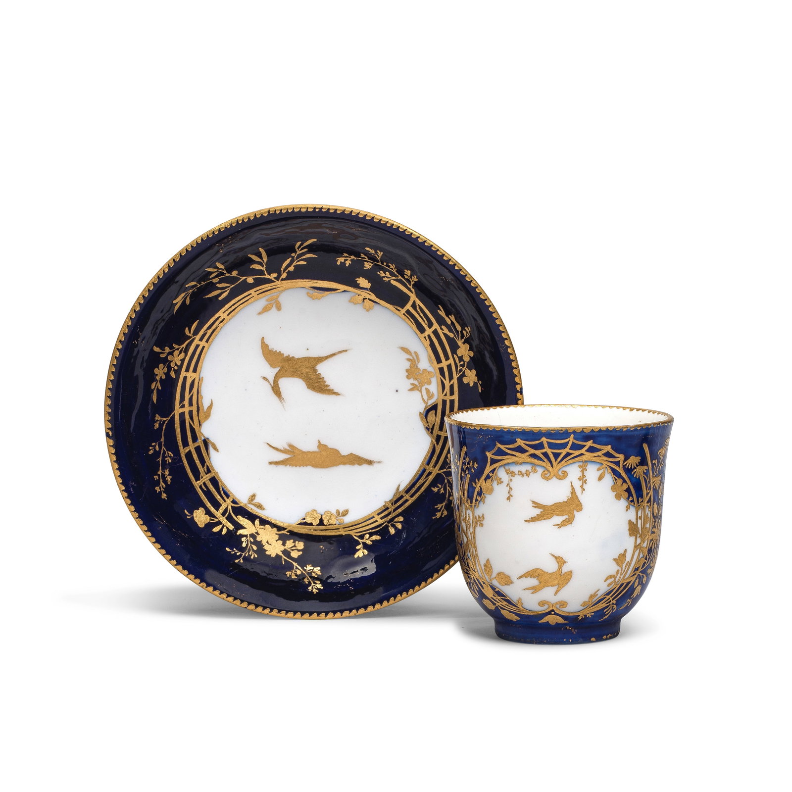 A Vincennes bleu-lapis ground cup and a saucer (gobelet 'Calabre' et soucoupe), circa 1753-54: A Vincennes bleu-lapis ground cup and a saucer (gobelet 'Calabre' et soucoupe), circa 1753-54 Of the first size, reserved with panels decorated with gilt birds within elaborate and finely-tooled folia