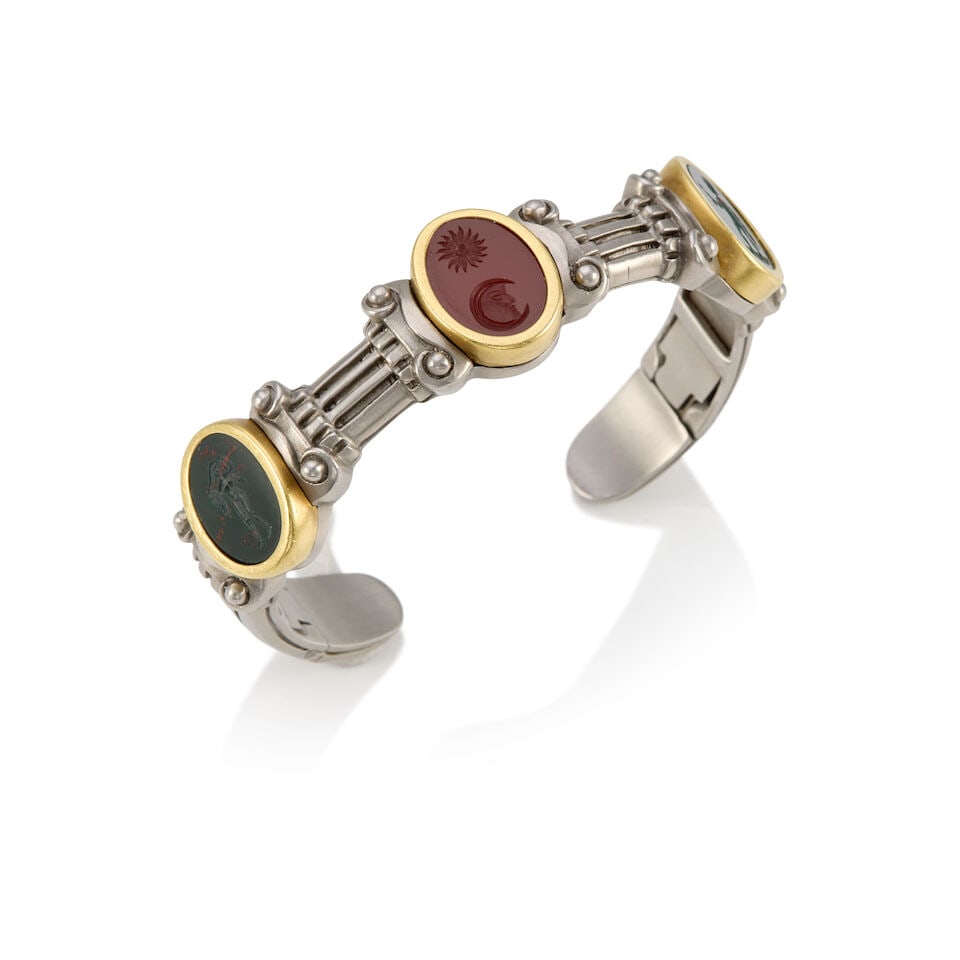 KIESELSTEN-CORD: A STAINLESS STEEL, 18K YELLOW GOLD, AND HARDSTONE INTAGLIO CUFF BRACELET: KIESELSTEN-CORD: A STAINLESS STEEL, 18K YELLOW GOLD, AND HARDSTONE INTAGLIO CUFF BRACELET • Two oval shaped and carved bloodstones measuring approximately 14.53mm x 11.09mm • One oval