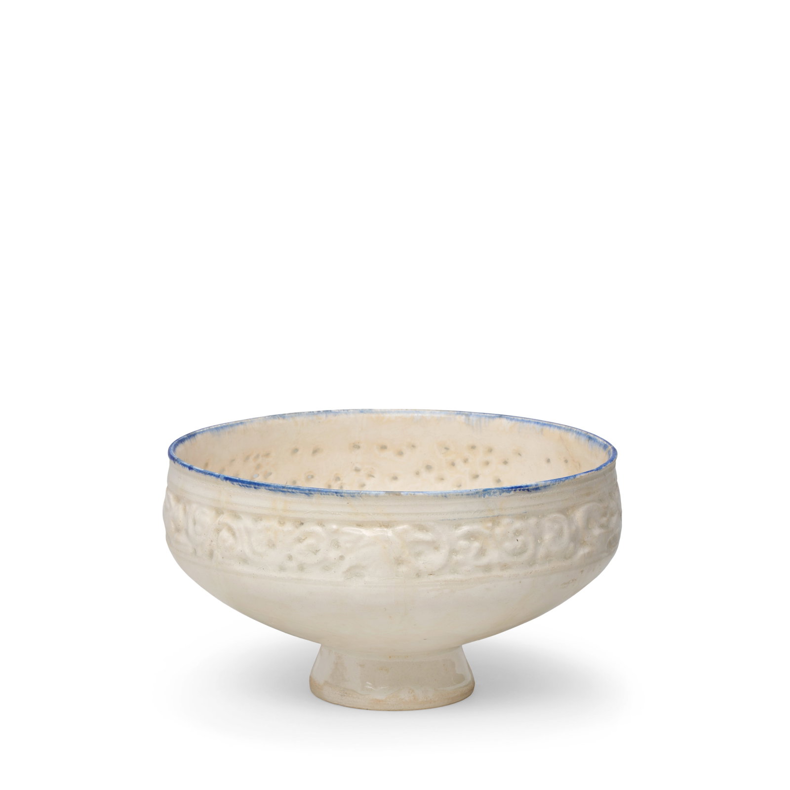A moulded and pierced pottery bowl Persia, late 12th/ early 13th Century: A moulded and pierced pottery bowl Persia, late 12th/ early 13th Century Of flaring form with slightly inverted upper section on a high foot, decorated in a transparent glaze with cobalt-blue rim, upp