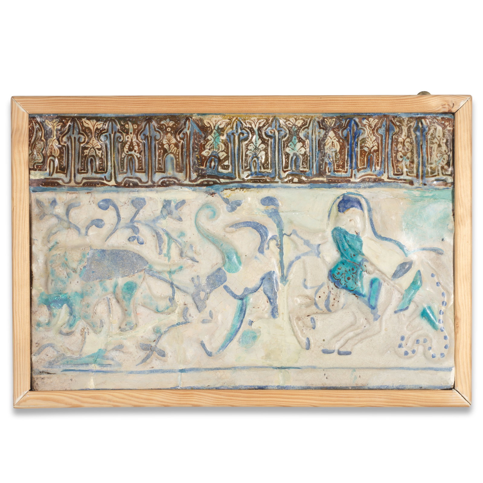 A Kashan lustre moulded pottery tile Persia, 13/ 14th Century: A Kashan lustre moulded pottery tile Persia, 13/ 14th Century Of rectangular form, decorated in cobalt blue, turquoise and golden brown on a cream ground with an equestrian hunter, elephant and quadru