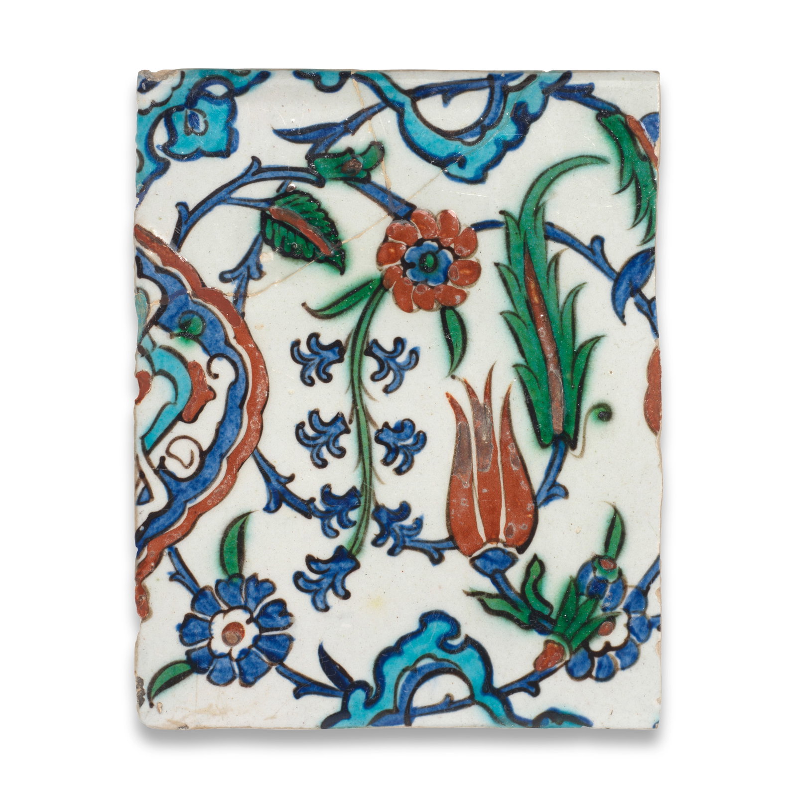 An Iznik pottery tile, Turkey, 17th Century: An Iznik pottery tile, Turkey, 17th Century Of rectangular form, decorated in raised-red, cobalt blue, turquoise, green and black on a white ground with a partial palmette and scrolling stems with a t