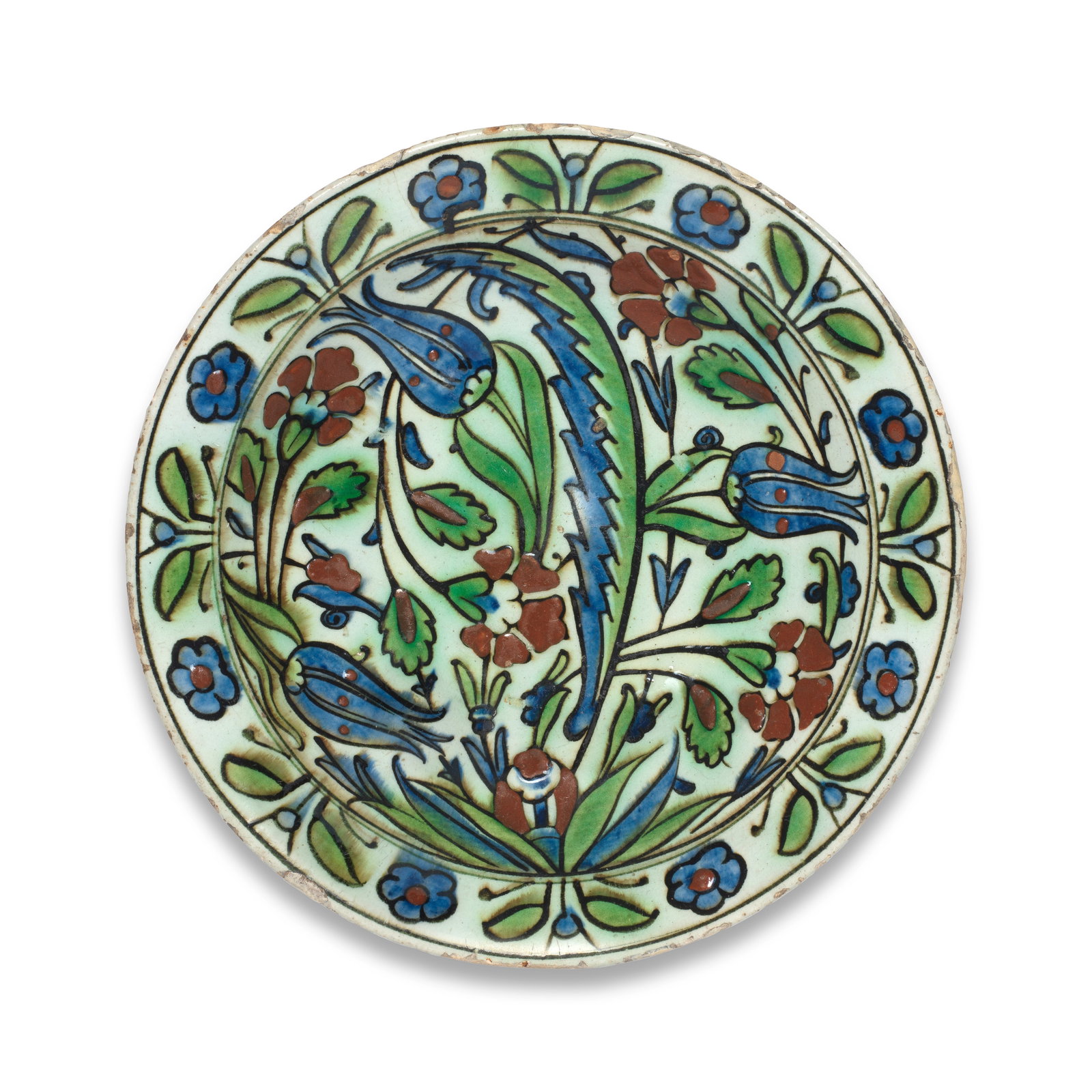 An Iznik pottery dish, Turkey, 17th Century: An Iznik pottery dish, Turkey, 17th Century Of shallow circular form with a gently everted rim on a short foot, decorated in raised-red, green, blue and outlined in black, the centre with a tuft of le