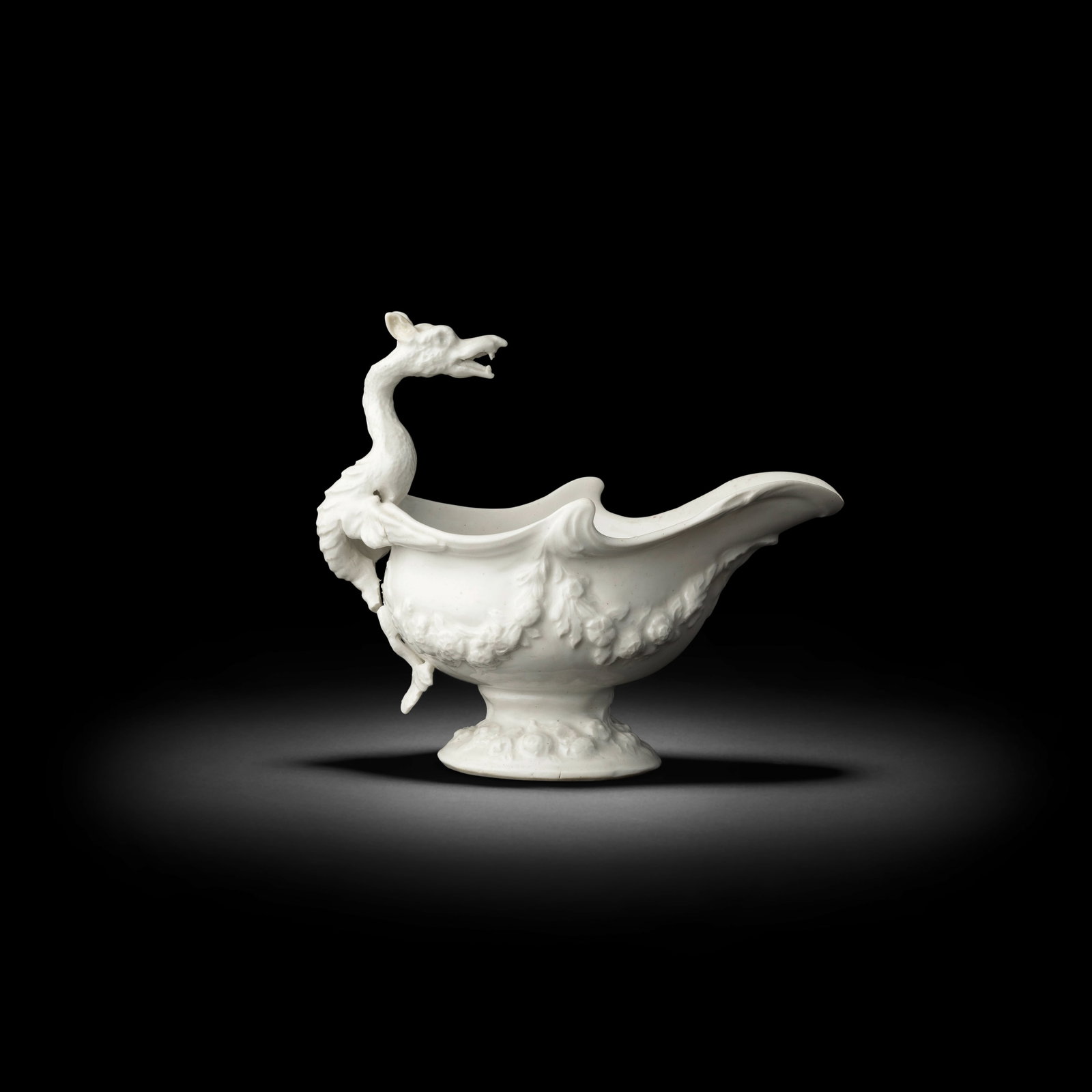 A good Bow white sauceboat, circa 1750: A good Bow white sauceboat, circa 1750 Of oval silver shape with a pronounced pouring lip, the handle finely modelled in the form of an upright dragon, the ferocious beast with a curved scaly body, sm