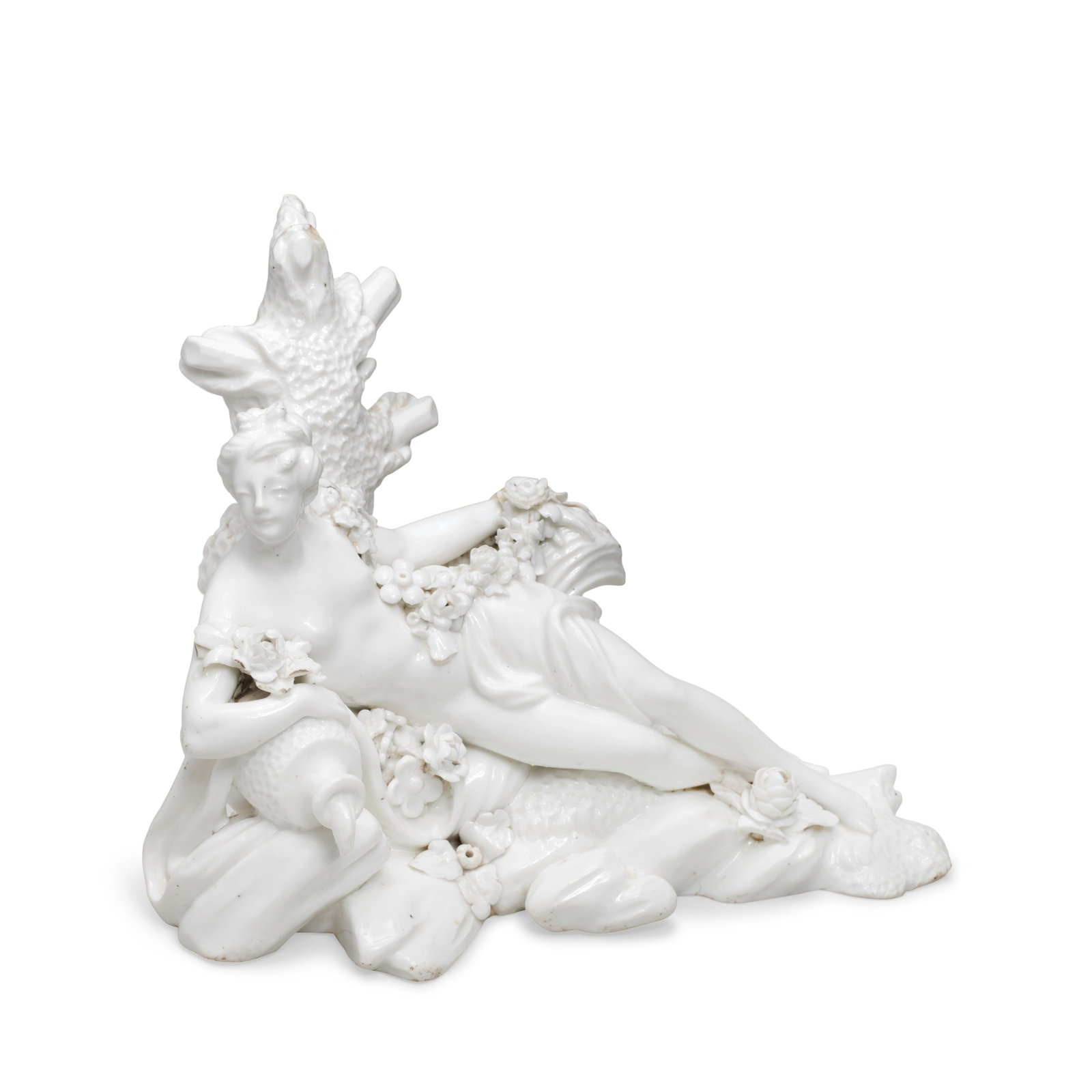 A Vincennes white figure of a Naiad or 'Baigneuse avec urne', circa 1750: A Vincennes white figure of a Naiad or 'Baigneuse avec urne', circa 1750 Modelled reclining on rockwork with her right arm on an urn, the figure with draperies and flower garlands, the reverse with a 