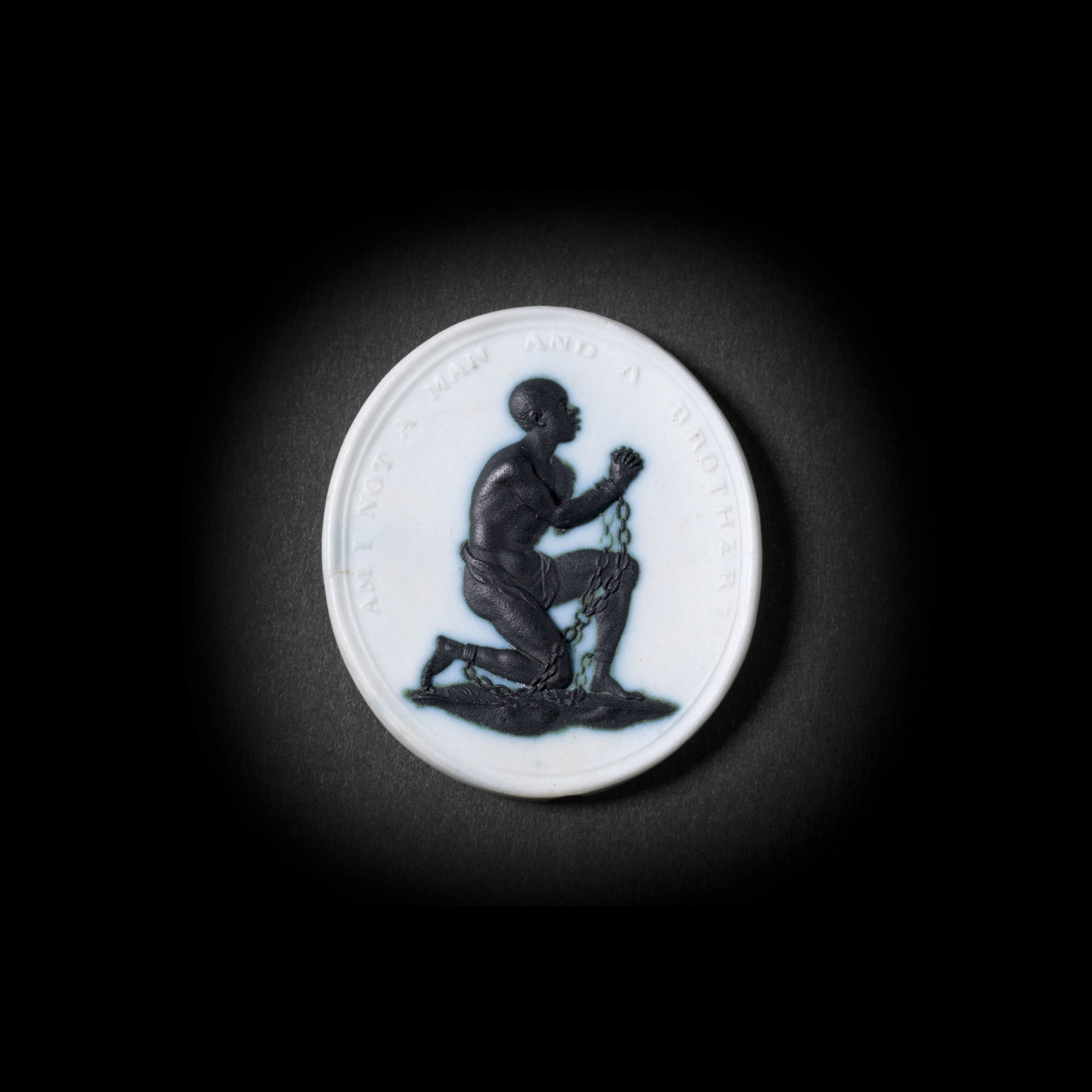 A Wedgwood anti-slavery medallion, circa 1790: A Wedgwood anti-slavery medallion, circa 1790 Of oval shape composed of black and white jasperware, an enslaved man depicted in profile, kneeling on one knee, his hands together, situated beneath the 