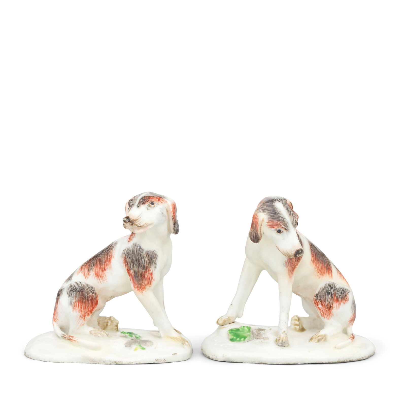 A rare pair of Bow models of 'Dismal Hounds', circa 1758-60: A rare pair of Bow models of 'Dismal Hounds', circa 1758-60 Seated on plain bases applied with leaves, the dog in lively attitude, his ears back and his mouth partially open, the bitch in a more refle