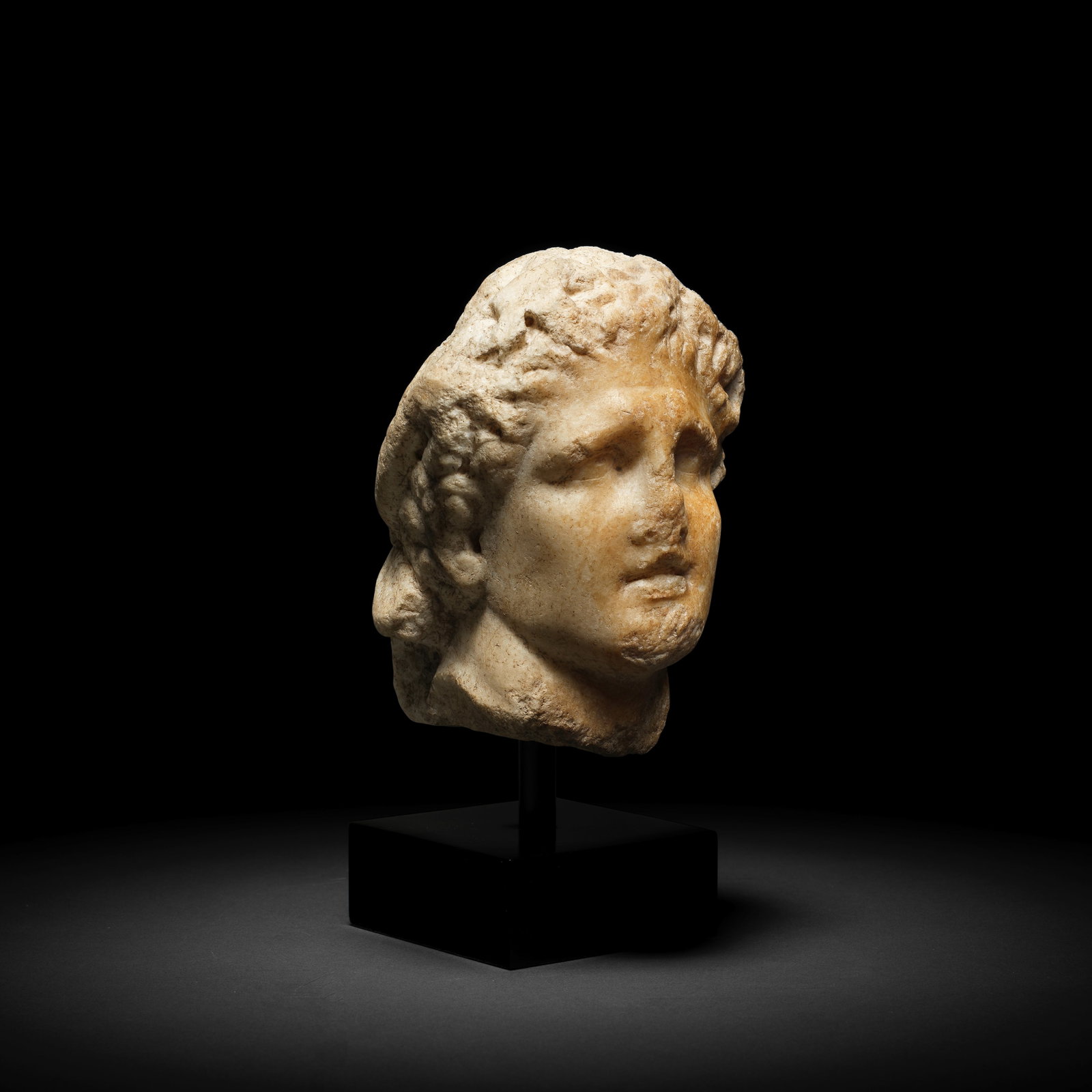 A Roman marble portrait head of Alexander the Great: A Roman marble portrait head of Alexander the Great Circa 1st Century B.C.-1st Century A.D. 16.5cm high Footnotes: Provenance: Private collection, Belgium, 1980s. with Ariadne Galleries, New York and 