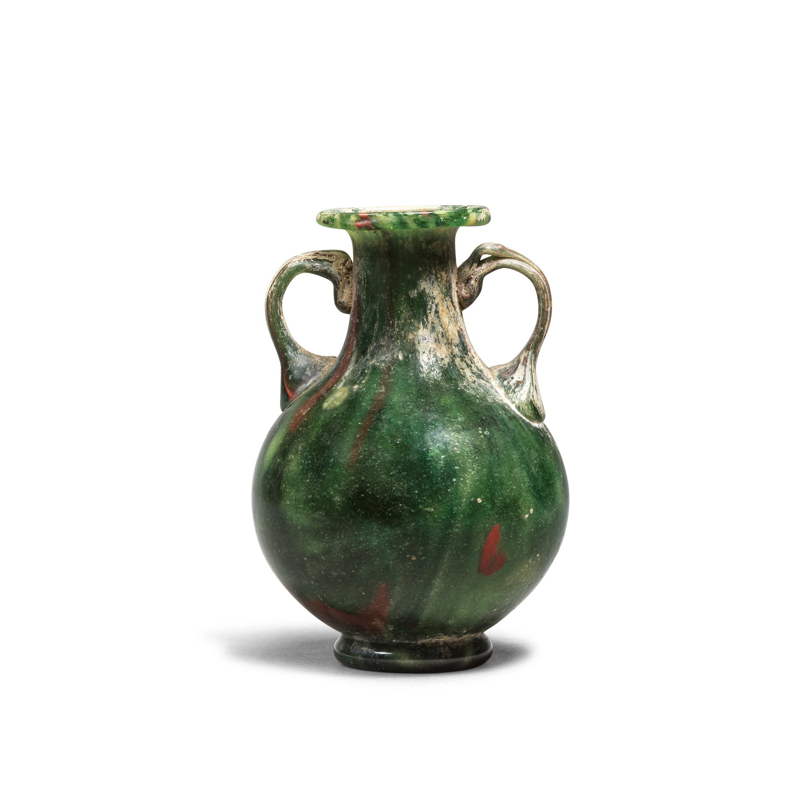 A Roman fused mosaic and blown glass amphora of green, red, yellow and white glass: A Roman fused mosaic and blown glass amphora of green, red, yellow and white glass Circa early 1st Century A.D. 7.2cm high Footnotes: Provenance: with Marvin Kagan Art, Inc., New York. Schefler Collec