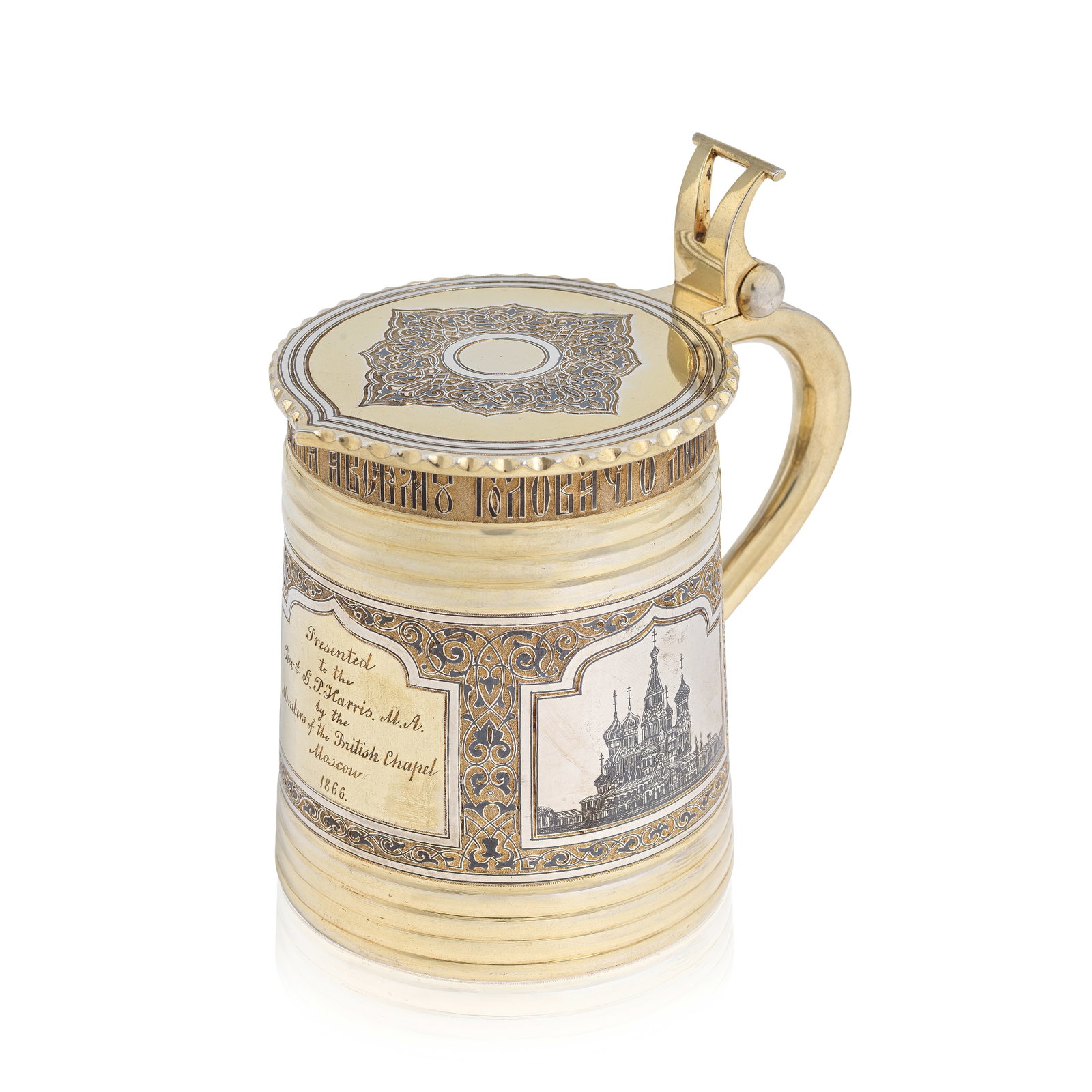 A Russian silver-gilt and niello tankard Vasily Semenov, Moscow, 1865: A Russian silver-gilt and niello tankard Vasily Semenov, Moscow, 1865 Of tapering cylindrical form, with flat cover with faceted edge and scroll thumbpiece, and plain scroll handle, the rim with engra