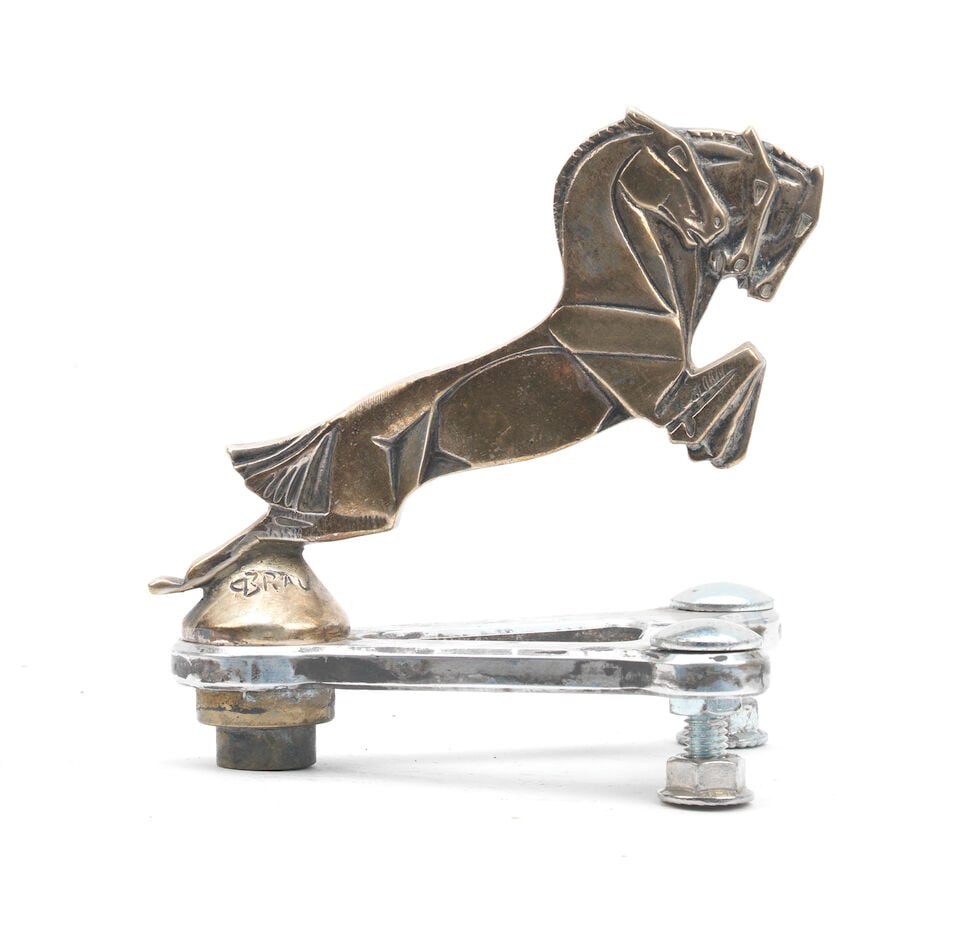 A 'Galloping Horses' mascot by Casimir Brau, French, 1920s,: A 'Galloping Horses' mascot by Casimir Brau, French, 1920s, signed on base 'C. Brau' and stamped 'Depose', the nickel-plated bronze cast in relief, 10cm high, on a metal display base Lot to be sold wi