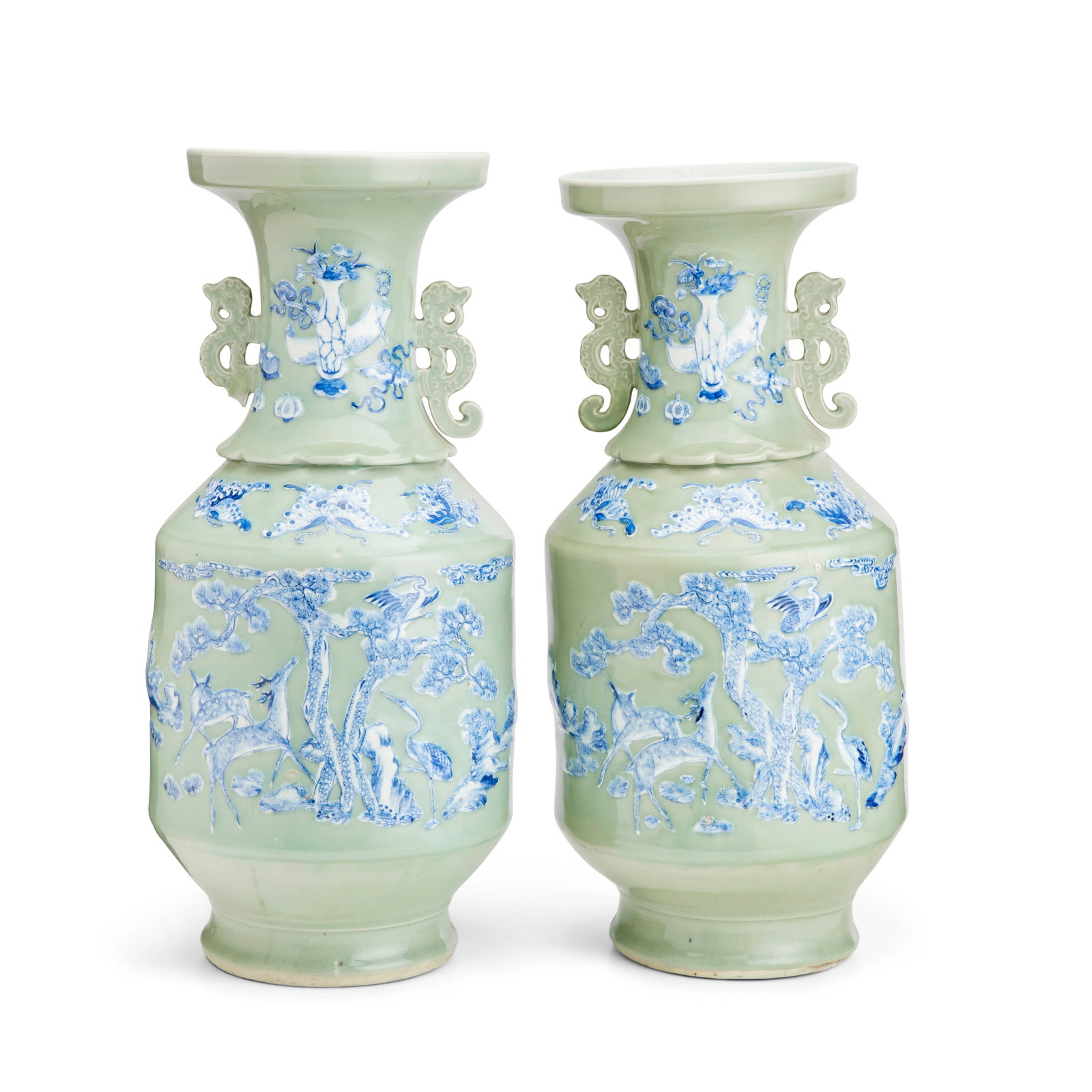 A pair of Chinese celadon vases 19th century (2): A pair of Chinese celadon vases 19th century With blue and white relief decoration of deer, pine trees, and butterflies, with dragon handles, 57cm high (2). For further information on this lot please 