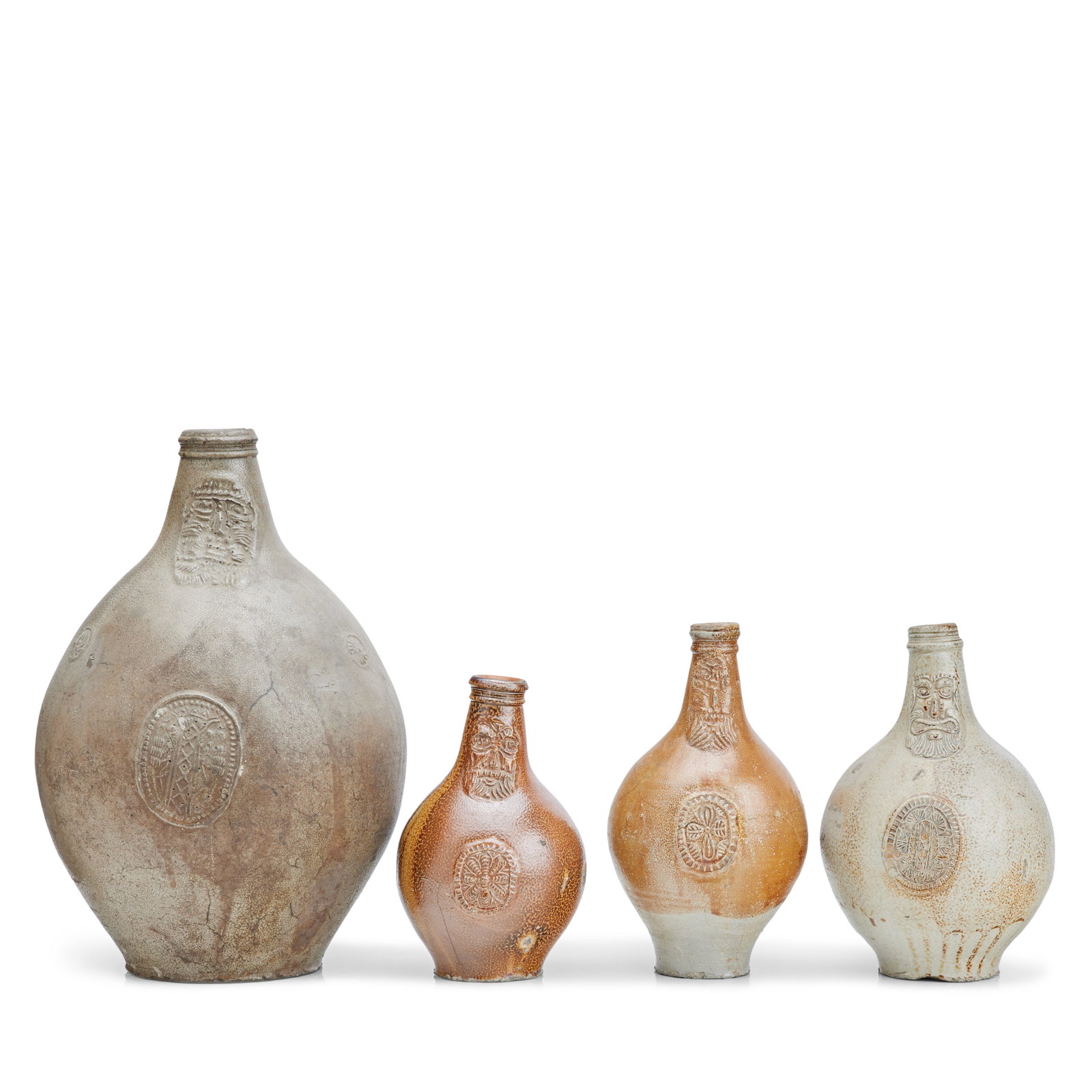 Four German stoneware 'Bellarmine' flagons 17th century: Four German stoneware 'Bellarmine' flagons 17th century Each with mask and additional medallion, the largest 40cm high (4) Footnotes: The buff coloured example with label inscribed 'The Rt Hon Sir Her