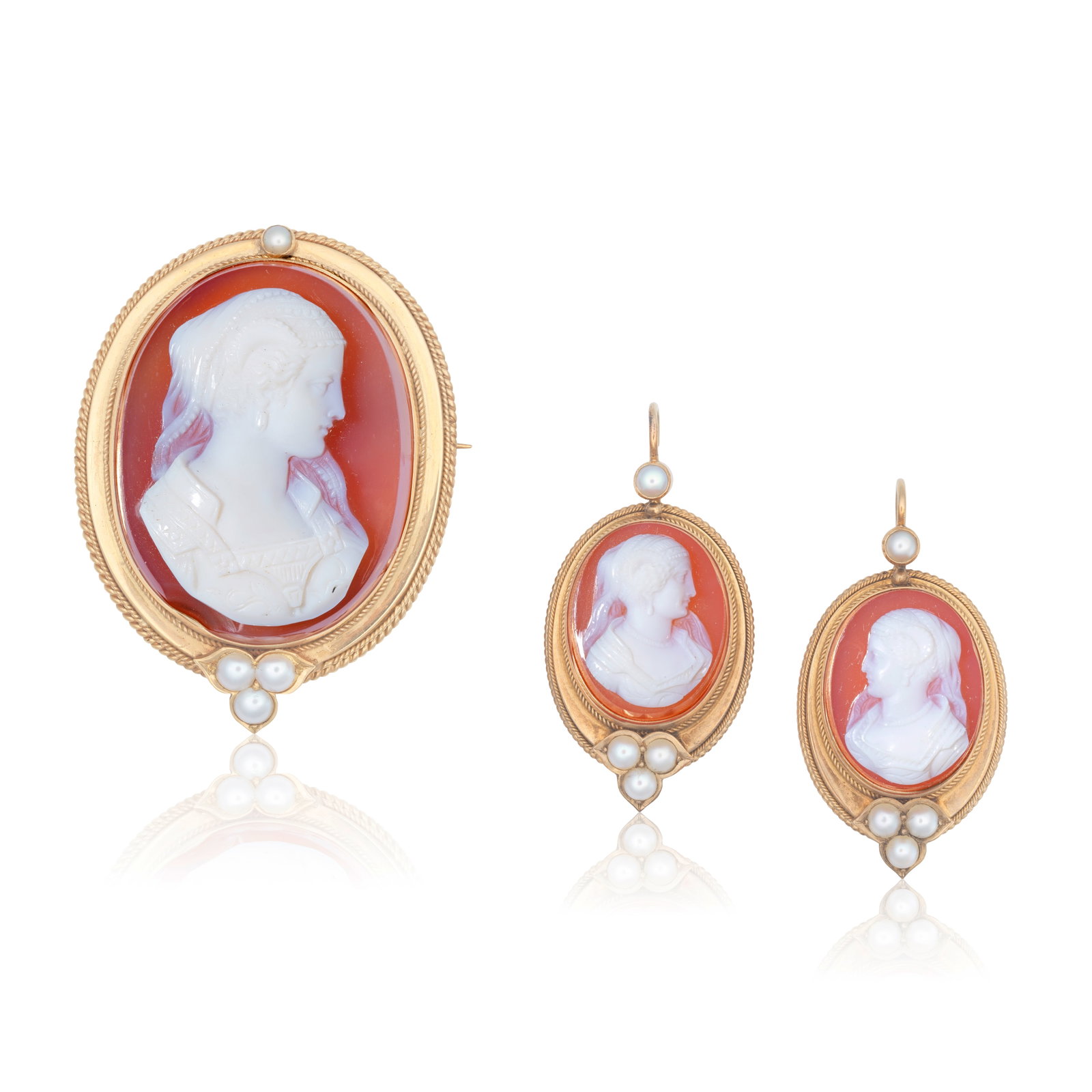 CAMEO BROOCH AND EARRING SUITE, CIRCA 1870: CAMEO BROOCH AND EARRING SUITE, CIRCA 1870 The carved shells depicting the bust of a woman, mounted within a tiered ropetwist surround, accented by seed pearls, brooch length 4.5cm, earring length 3.8