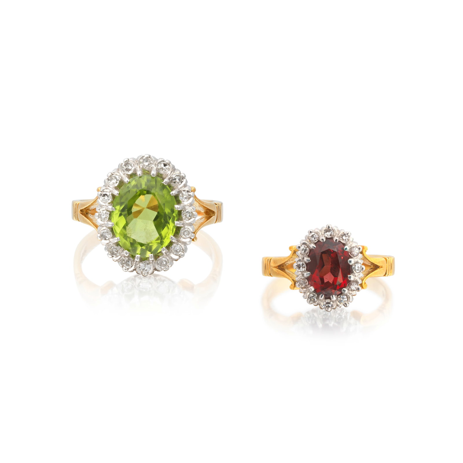 TWO GEM-SET AND DIAMOND CLUSTER RINGS, LATE 20TH CENTURY (2): TWO GEM-SET AND DIAMOND CLUSTER RINGS, LATE 20TH CENTURY 1st: The oval-cut peridot to a border of single-cut diamonds, mounted in 18 carat gold, 1979, 2nd: The oval-cut garnet to a border of single-cu