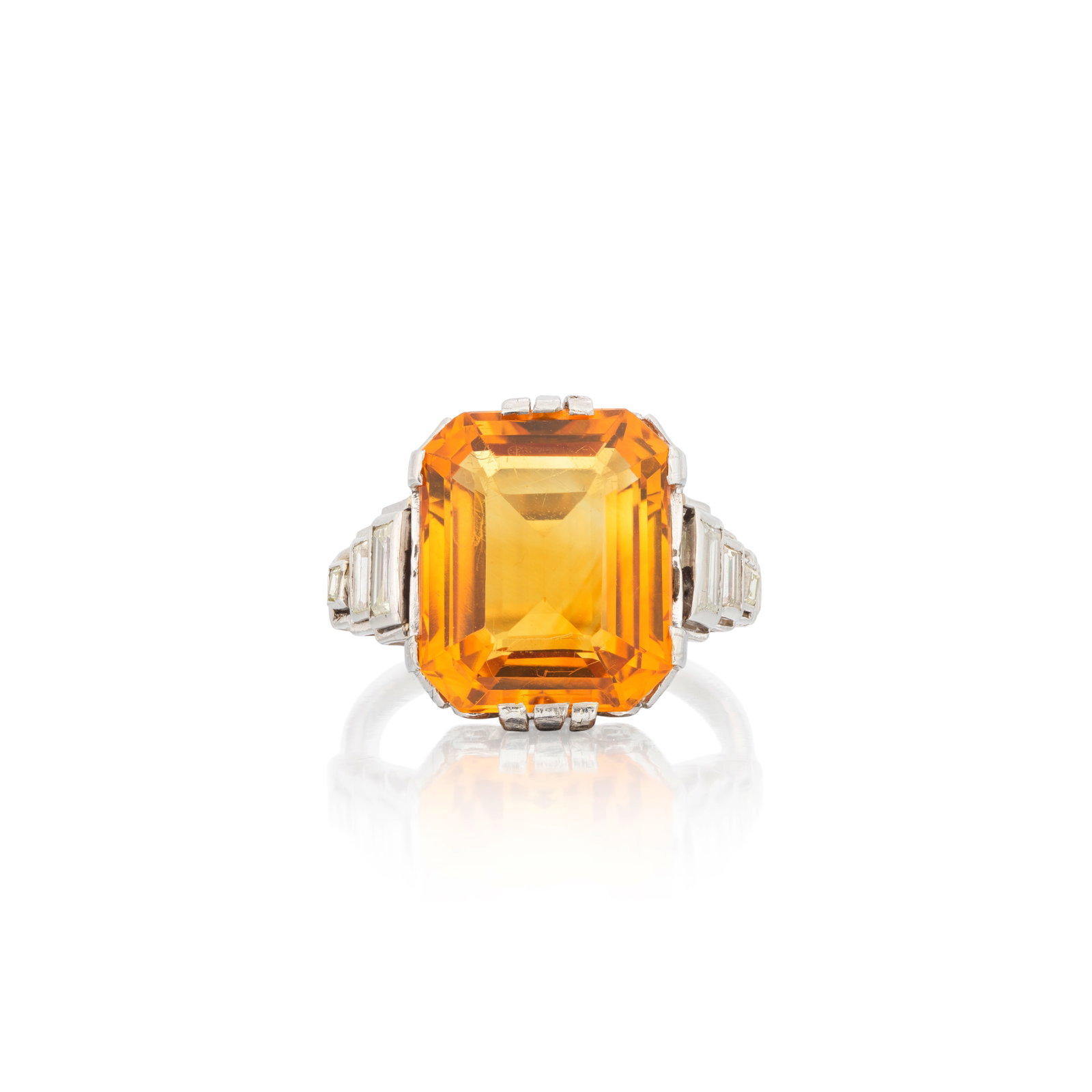 CITRINE RING, CIRCA 1930: CITRINE RING, CIRCA 1930 The octagonal step-cut citrine between tiered shoulders of baguette-cut diamonds, ring size approx. O For further information on this lot please visit Bonhams.com