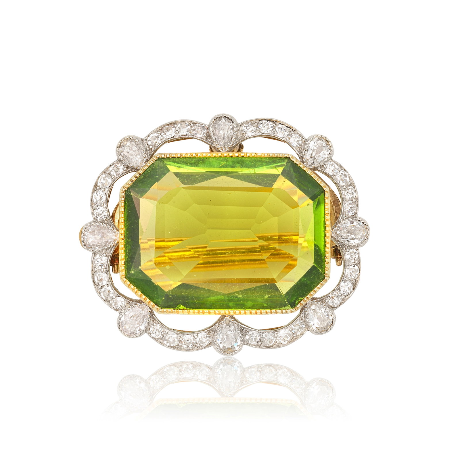 PERIDOT AND DIAMOND BROOCH/PENDANT, CIRCA 1910: PERIDOT AND DIAMOND BROOCH/PENDANT, CIRCA 1910 The octagonal step-cut peridot to a surround of undulating design, set with old single and pear-cut diamonds, millegrain-set in gold and platinum,