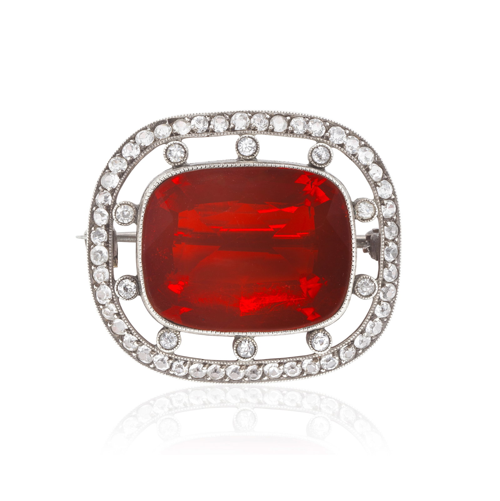 FIRE OPAL BROOCH, CIRCA 1915: FIRE OPAL BROOCH, CIRCA 1915 The cushion-cut fire opal millegrain-set to an openwork border of circular-cut white gemstones, mounted in silver, length 2.7cm For further information on this lot please 