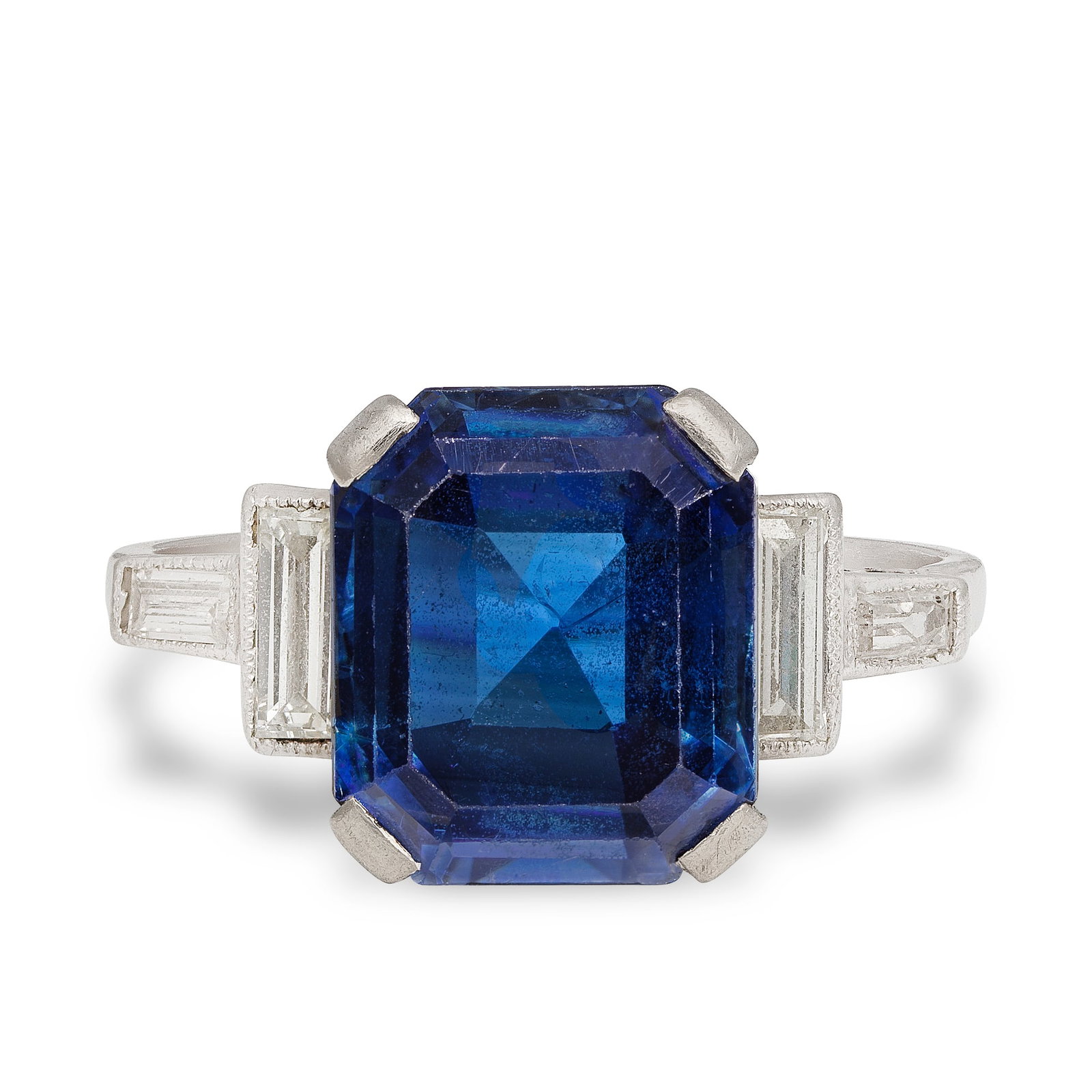 SAPPHIRE SINGLE-STONE RING: SAPPHIRE SINGLE-STONE RING The octagonal step-cut sapphire between shoulders of baguette-cut diamonds, ring size approx. T½ For further information on this lot please visit Bonhams.com
