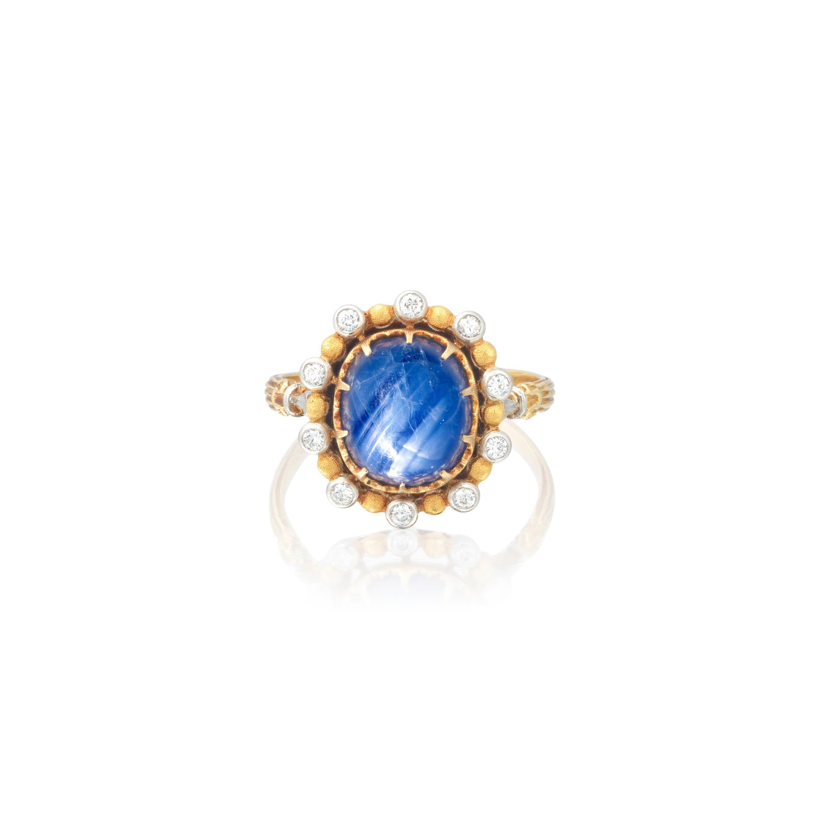 MARIO BUCCELLATI: STAR SAPPHIRE AND DIAMOND RING: MARIO BUCCELLATI: STAR SAPPHIRE AND DIAMOND RING The cushion-shaped star sapphire cabochon set within a brilliant-cut diamond surround, to a bicoloured mount of textured finish, signed M. Buccellati,