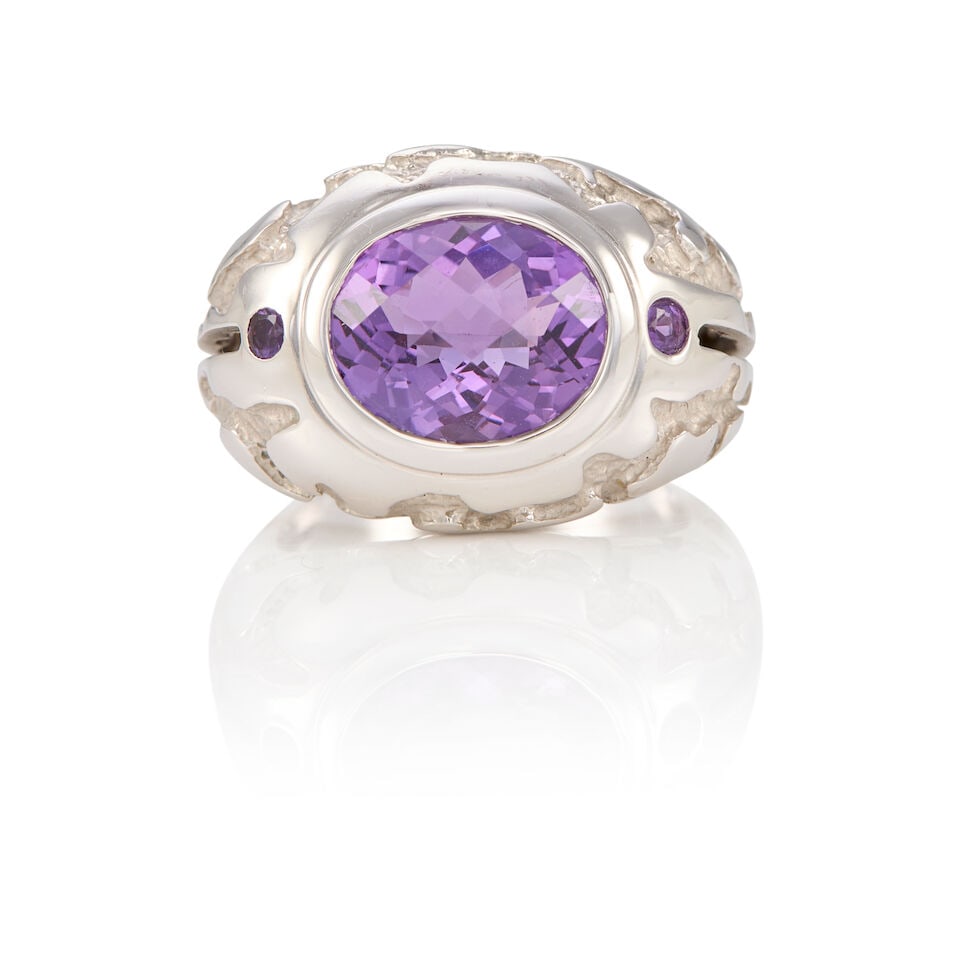 14K WHITE GOLD AND AMETHYST RING: 14K WHITE GOLD AND AMETHYST RING • One oval amethyst weighing approximately 4.25 carats total • Two round shaped amethyst weighing approximately 0.08 carat total • Size 7 1/4 •