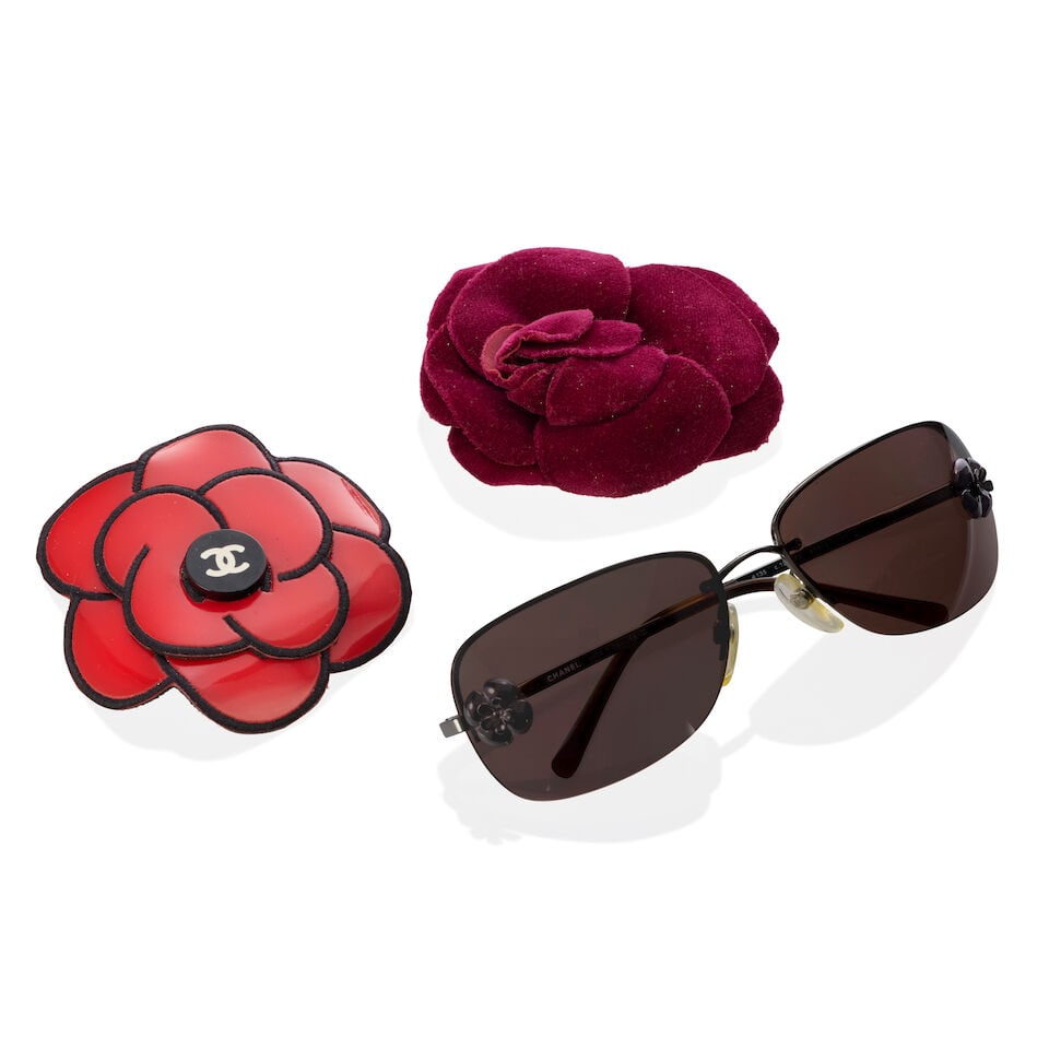 Chanel: Two Camellia Pin Brooches and a Pair of Sunglasses Spring 1995 (includes sunglasses case): Chanel: Two Camellia Pin Brooches and a Pair of Sunglasses Spring 1995 Creative Director: Karl Lagerfeld To include a red patent leather camellia pin brooch, Barbie Collection, Spring 1995, a purple v