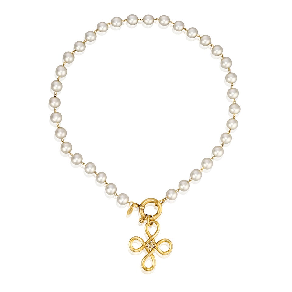 Chanel: a Simulated Pearl and Cruciform Necklace Spring 1993: Chanel: a Simulated Pearl and Cruciform Necklace Spring 1993 Creative Director: Karl Lagerfeld Simulated pearl necklace with chunky gold tone metal clasp and open cross pendant with central CC motif C