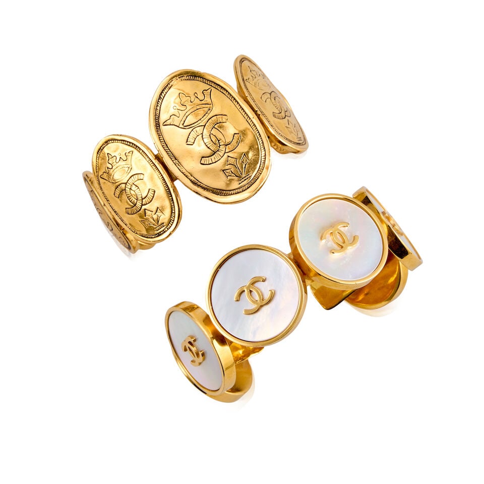 Chanel: Two Gilt Metal Cuff Bangles Spring 1993 and Collection 26, Autumn/Winter 1991: Chanel: Two Gilt Metal Cuff Bangles Spring 1993 and Collection 26, Autumn/Winter 1991 The first example features six mother-of-pearl effect CC buttons, Spring 1993, creative director: Karl Lagerfeld, 