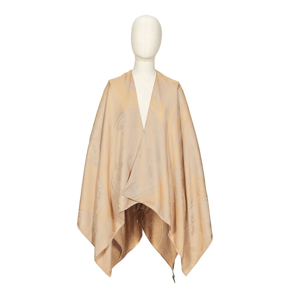 Hermès: a Kraft Cashmere New Libris Poncho (includes original tag): Hermès: a Kraft Cashmere New Libris Poncho Designed by Sandy Queudrus Caramel colour cashmere enhanced with a leather patch Condition Grade A- Approximately 140cm x 140cm, includes original tag F