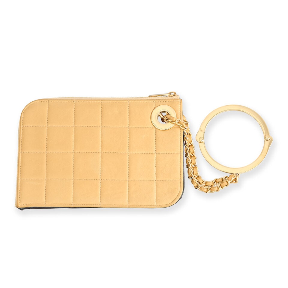 Chanel: a Beige Chocolate Bar Quilted Handcuff Pochette Spring 2002 (includes serial sticker, au...: Chanel: a Beige Chocolate Bar Quilted Handcuff Pochette Spring 2002 Creative Director: Karl Lagerfeld Square quilted beige leather with a black leather trim, gold tone hardware Condition Grade C+ 19cm