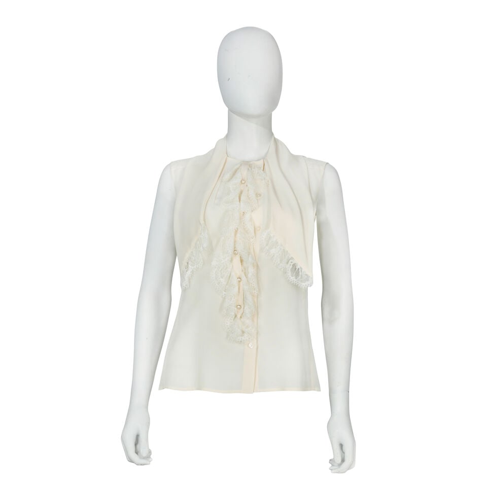 Chanel: a Cream Silk Blouse Autumn 2004, Runway Look 56: Chanel: a Cream Silk Blouse Autumn 2004, Runway Look 56 Creative Director: Karl Lagerfeld Sleeveless blouse with lace trim and scarf detail to neck, simulated pearl CC buttons Condition Grade A Labell