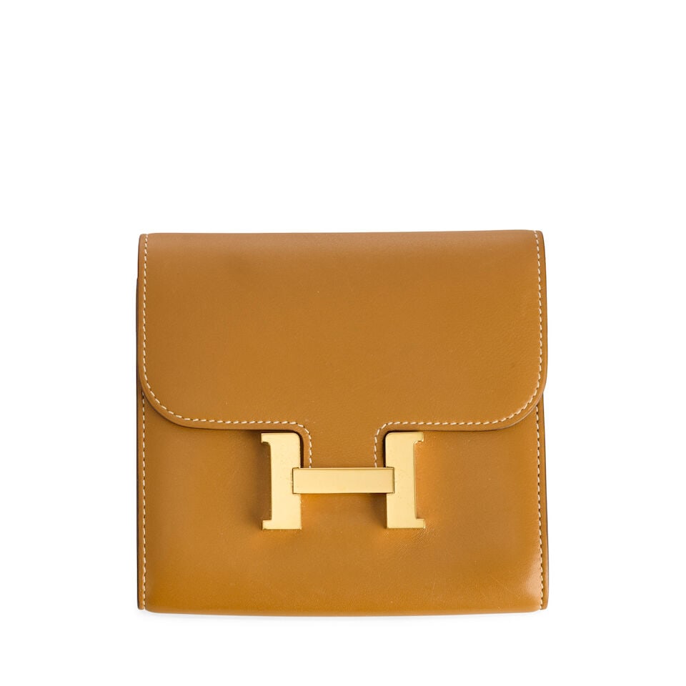 Hermès: a Natural Sable Butler Leather Constance Compact Wallet 2019: Hermès: a Natural Sable Butler Leather Constance Compact Wallet 2019 Central zipped compartments and card slots, slip pocket to reverse and gold hardware Condition Grade B- 13cm wide, 12cm high F