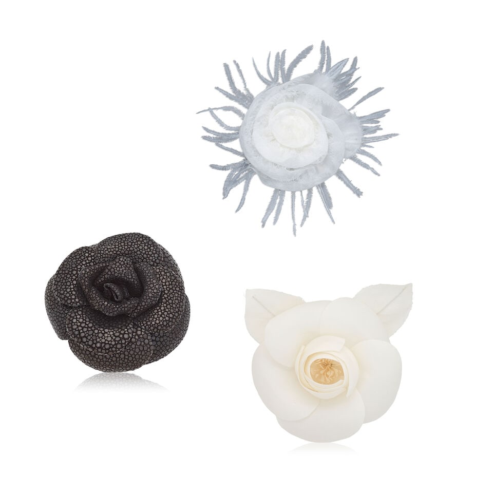 Chanel: Three Camellia Brooches Early 2000s (includes three boxes): Chanel: Three Camellia Brooches Early 2000s To include a white silk chiffon and feather example, a black shagreen (stingray) leather example, and a white silk example (3) Condition Grade A 7-11cm wide