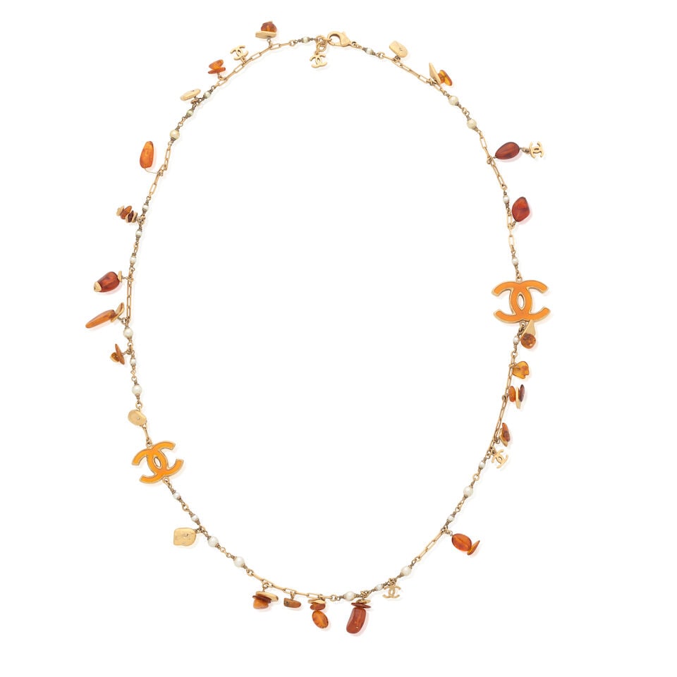 Chanel: an Amber Style CC Necklace Cruise 2011: Chanel: an Amber Style CC Necklace Cruise 2011 Creative Director: Karl Lagerfeld Amber style resin beads and CC charms on gold tone and simulated pearl chain Condition Grade B- 43cm drop Lot to be sol