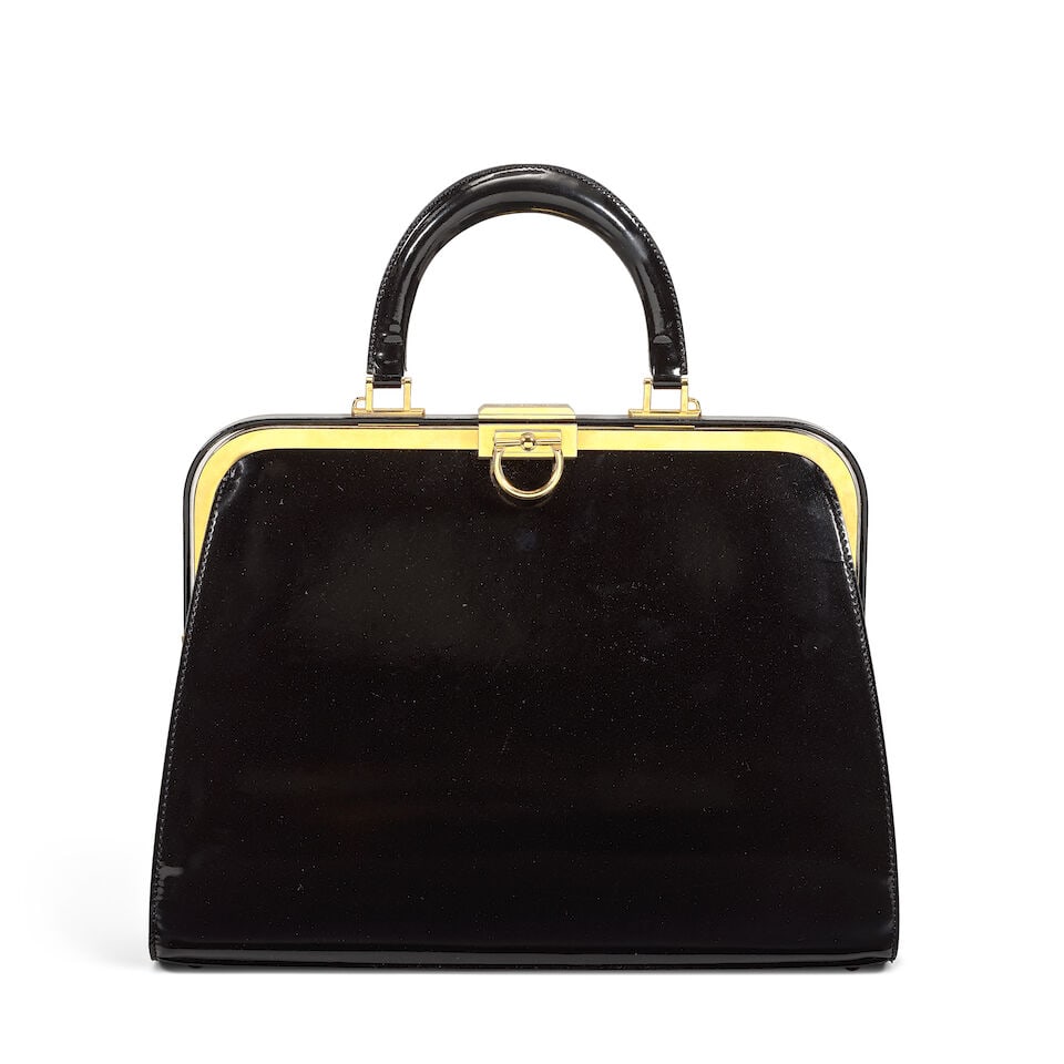 Christian Dior: a Black Patent Leather Top Handle Bag 1990s (includes dust bag): Christian Dior: a Black Patent Leather Top Handle Bag 1990s Creative Director: Gianfranco Ferré Shiny black leather with gold tone hardware and clasp fastening Condition Grade A- 33.5cm wide, 24c