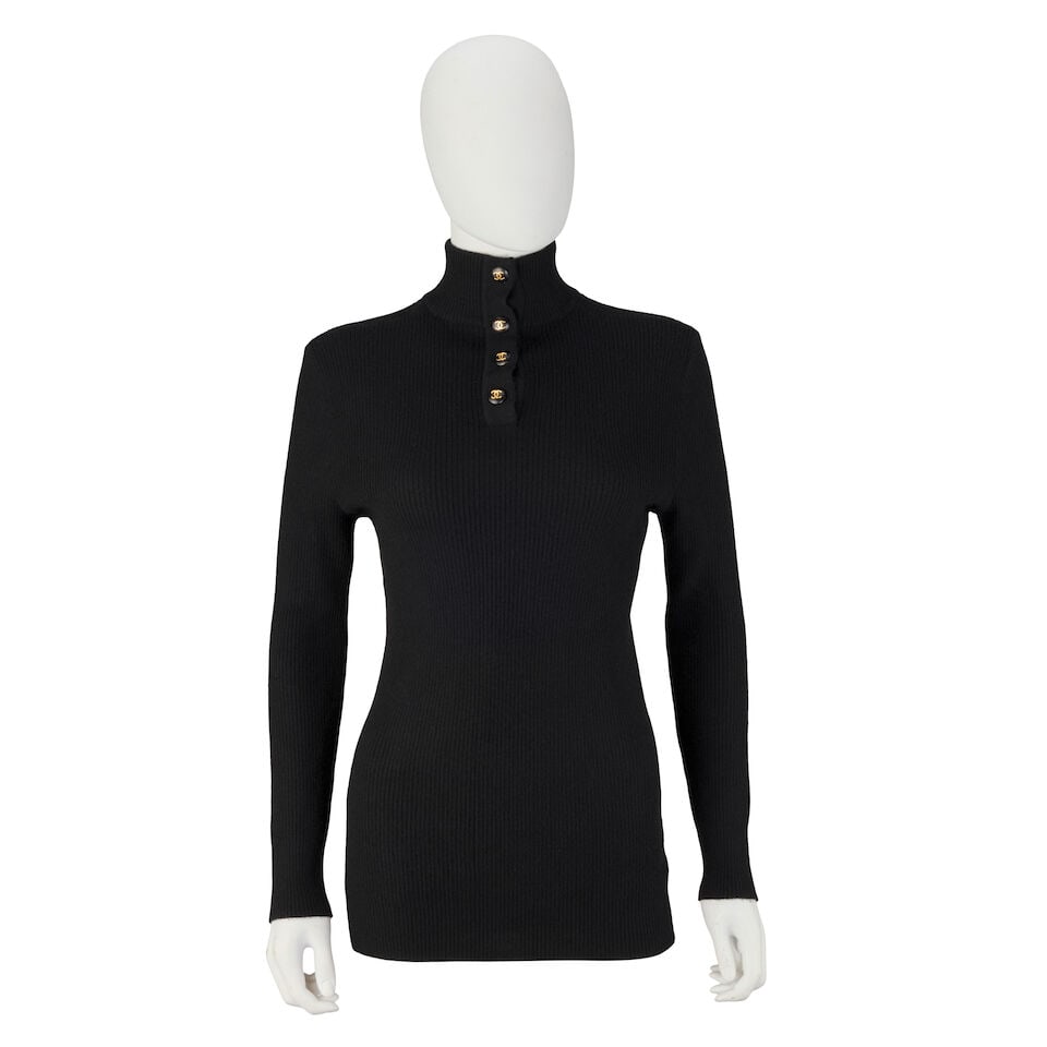 Chanel: a Black Knitted Cashmere Top Late 1990s/early 2000s: Chanel: a Black Knitted Cashmere Top Late 1990s/early 2000s Creative Director: Karl Lagerfeld Long sleeved high-neck top with four black and gold tone CC buttons to collar Condition Grade B- Size labe
