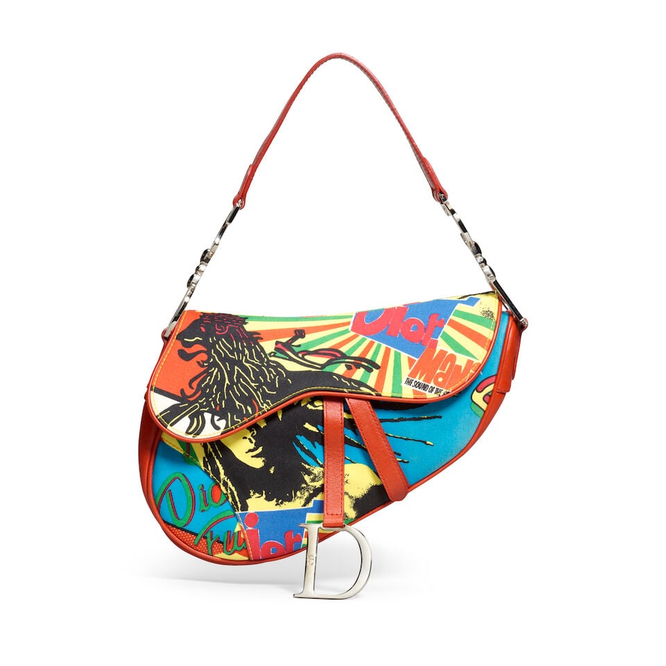 Christian Dior: a Bob Marley Canvas Saddle Bag Rasta Mania Collection, Autumn/Winter 2003 (inclu...: Christian Dior: a Bob Marley Canvas Saddle Bag Rasta Mania Collection, Autumn/Winter 2003 Creative Director: John Galliano Printed canvas with smooth red leather trim and silver tone hardware Conditio