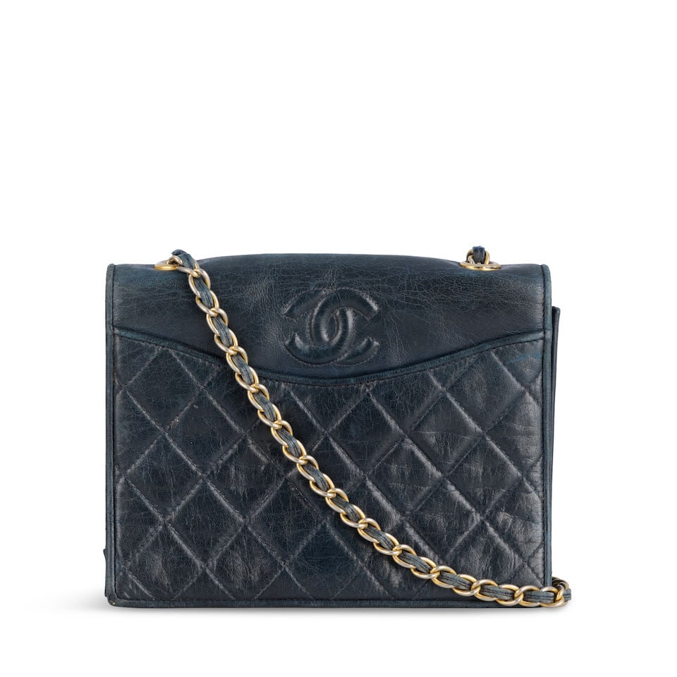 Chanel: a Navy Blue Lambskin Full Flap Shoulder Bag 1989-91 (includes serial sticker): Chanel: a Navy Blue Lambskin Full Flap Shoulder Bag 1989-91 Creative Director: Karl Lagerfeld Quilted lambskin with padded CC detail, gold tone hardware Condition Grade C- 19.5cm wide, 15cm high, 5cm 