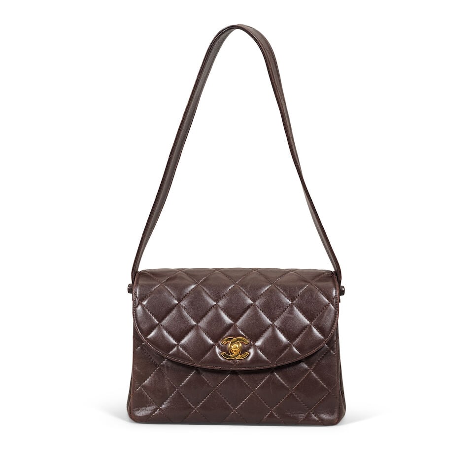 Chanel: a Brown Lambskin Top Handle Bag c. 1996-97 but date code missing (includes dust bag): Chanel: a Brown Lambskin Top Handle Bag c. 1996-97 but date code missing Creative Director: Karl Lagerfeld Quilted leather with leather shoulder strap and gold tone hardware Condition Grade B- 22cm wi