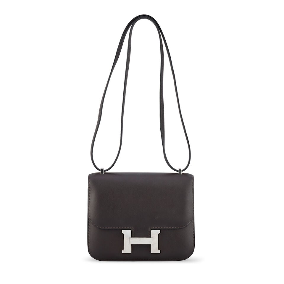 Hermès: an Ebene Swift Leather Mirror Constance 18 2024 (includes mirror, felt protector, b...: Hermès: an Ebene Swift Leather Mirror Constance 18 2024 Palladium hardware Condition Grade B 18cm wide, 16cm high, 4cm deep, 26/52cm shoulder drop, includes mirror, felt protector, booklet, dust 